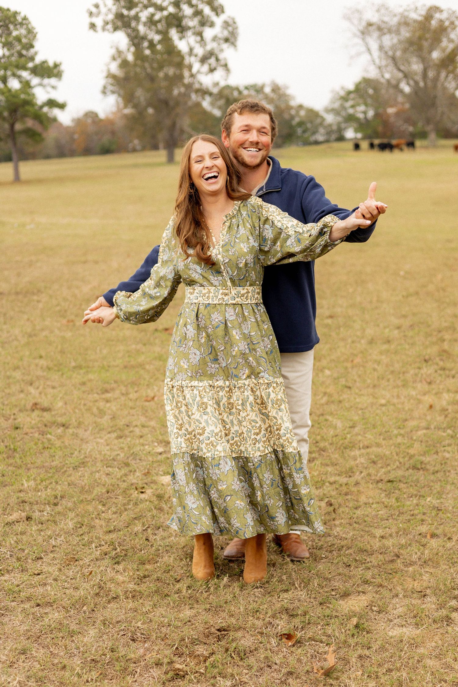 A couple sharing a joyful embrace while dancing in an autumn field.
