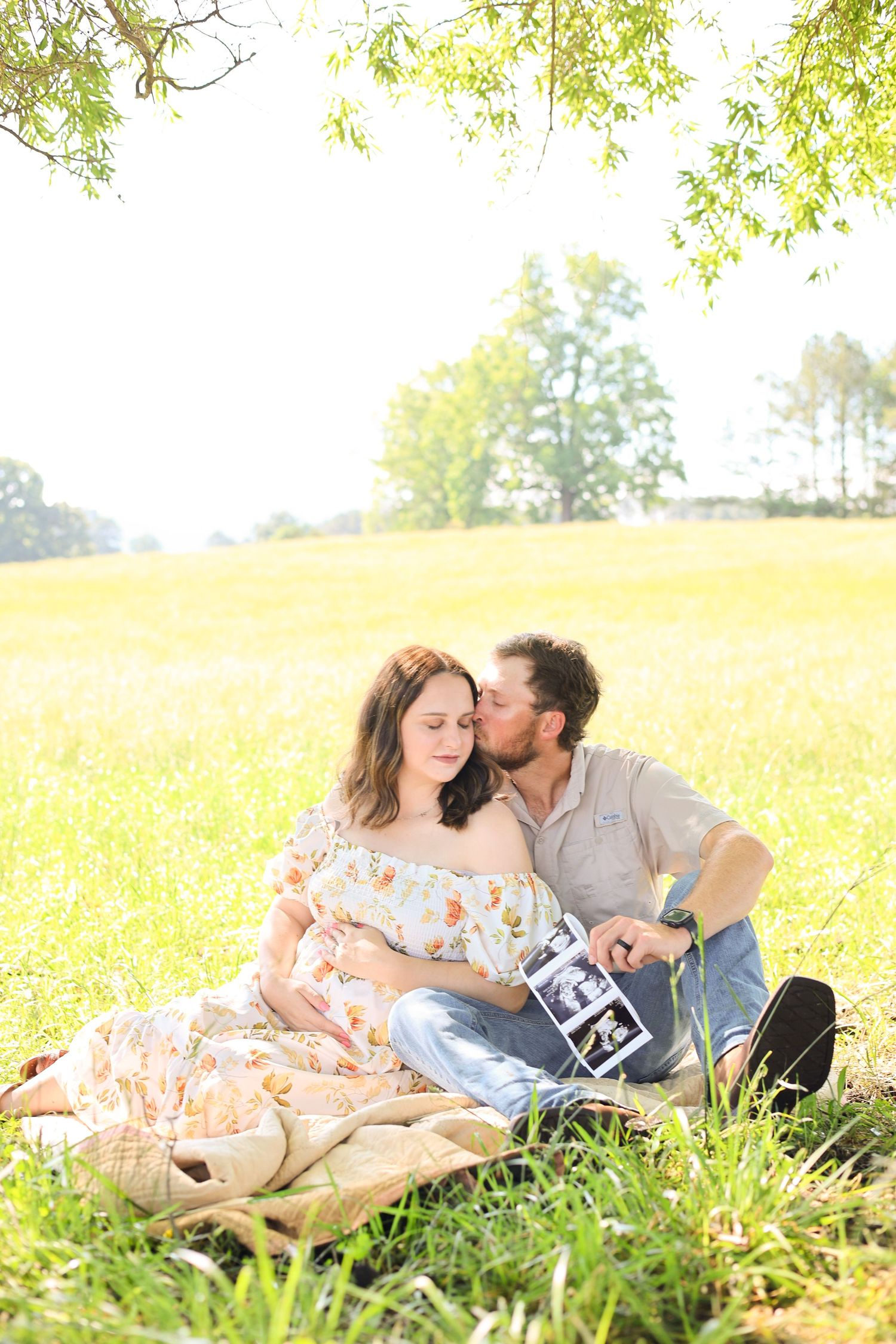 Family lying together on grass during golden hour photo session.