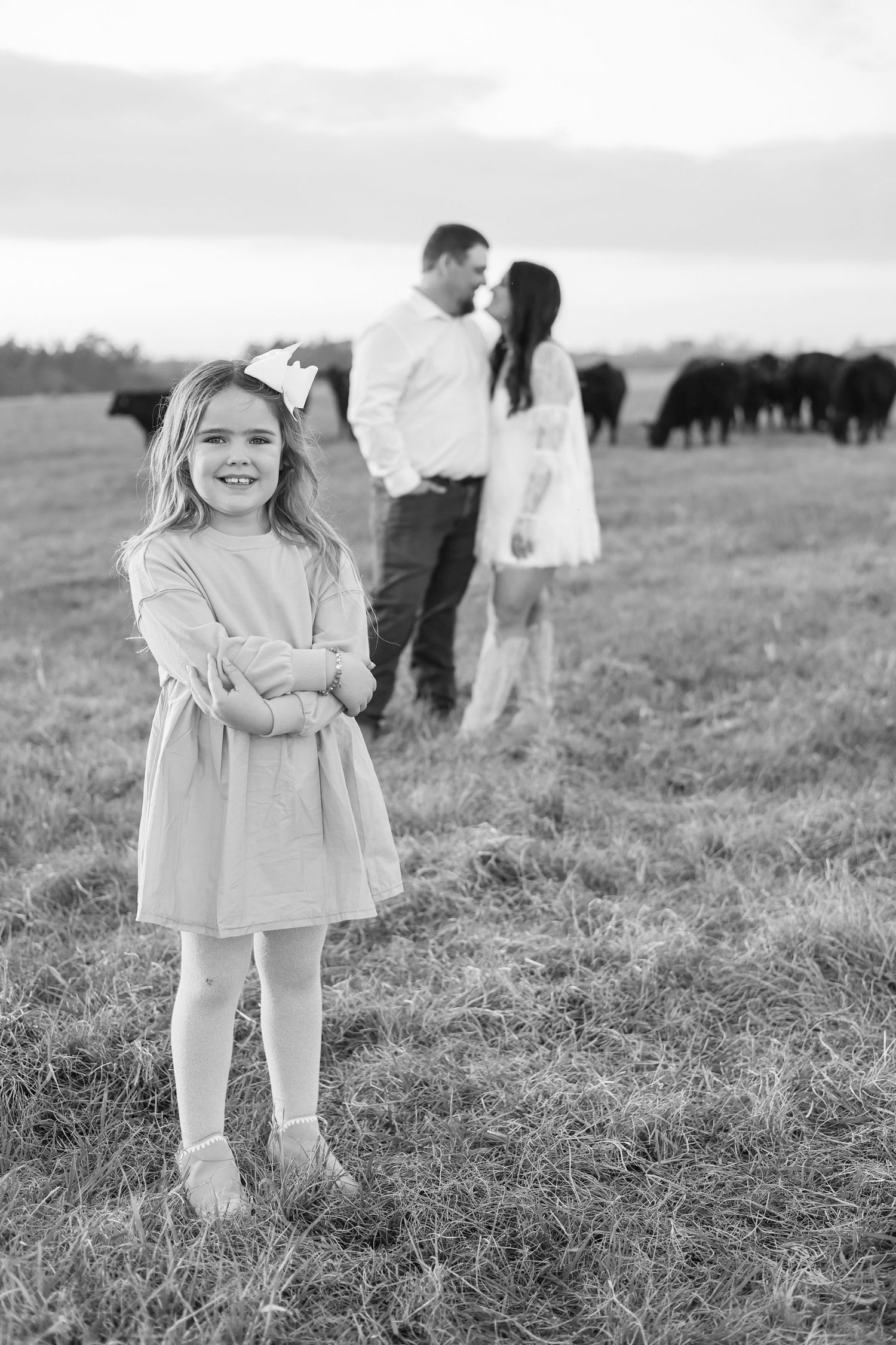 Black and white photographs of children playing in a grassy field on a cloudy day.