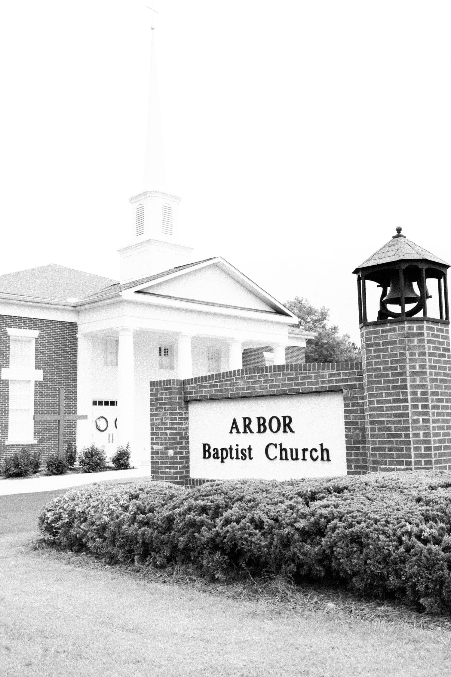 Black and white photo of Arbor Baptist Church exterior with bell tower and sign.