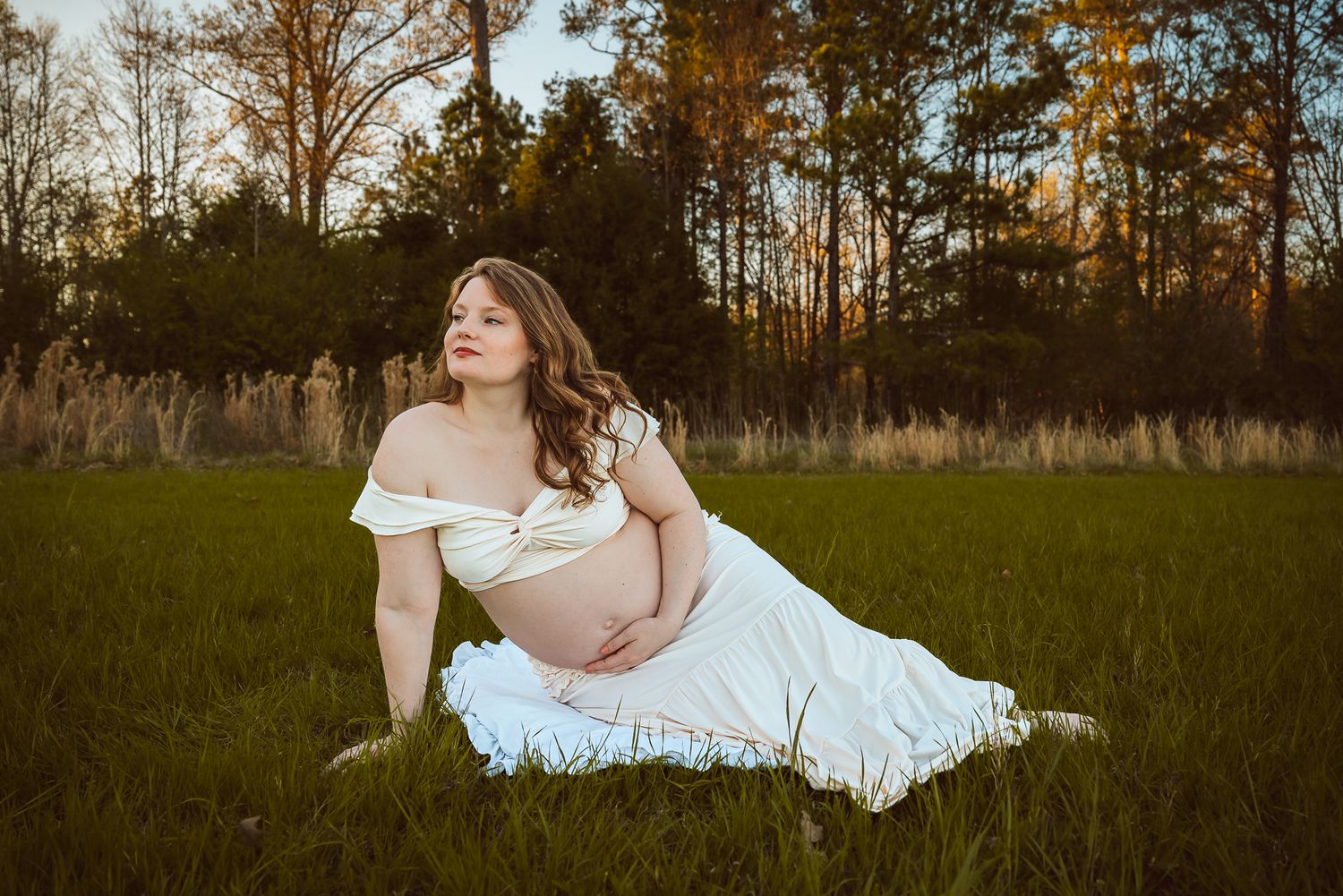 Ethereal maternity portraits taken in field at golden hour.