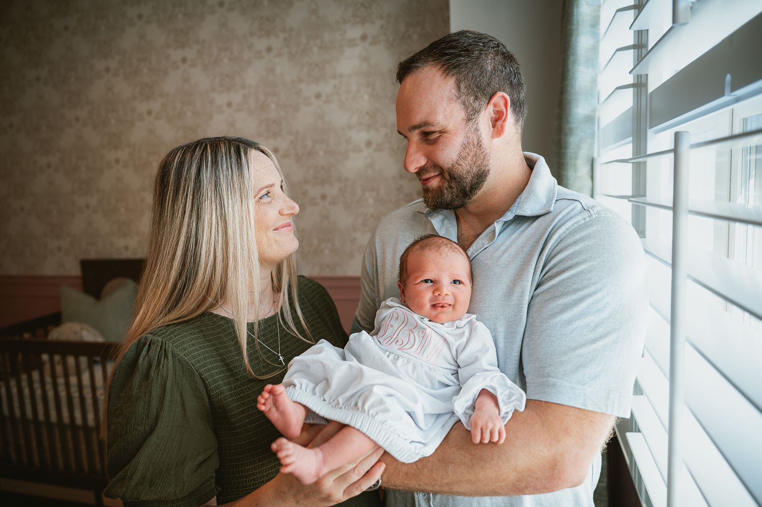 Family sharing tender moment by window with natural light streaming in.