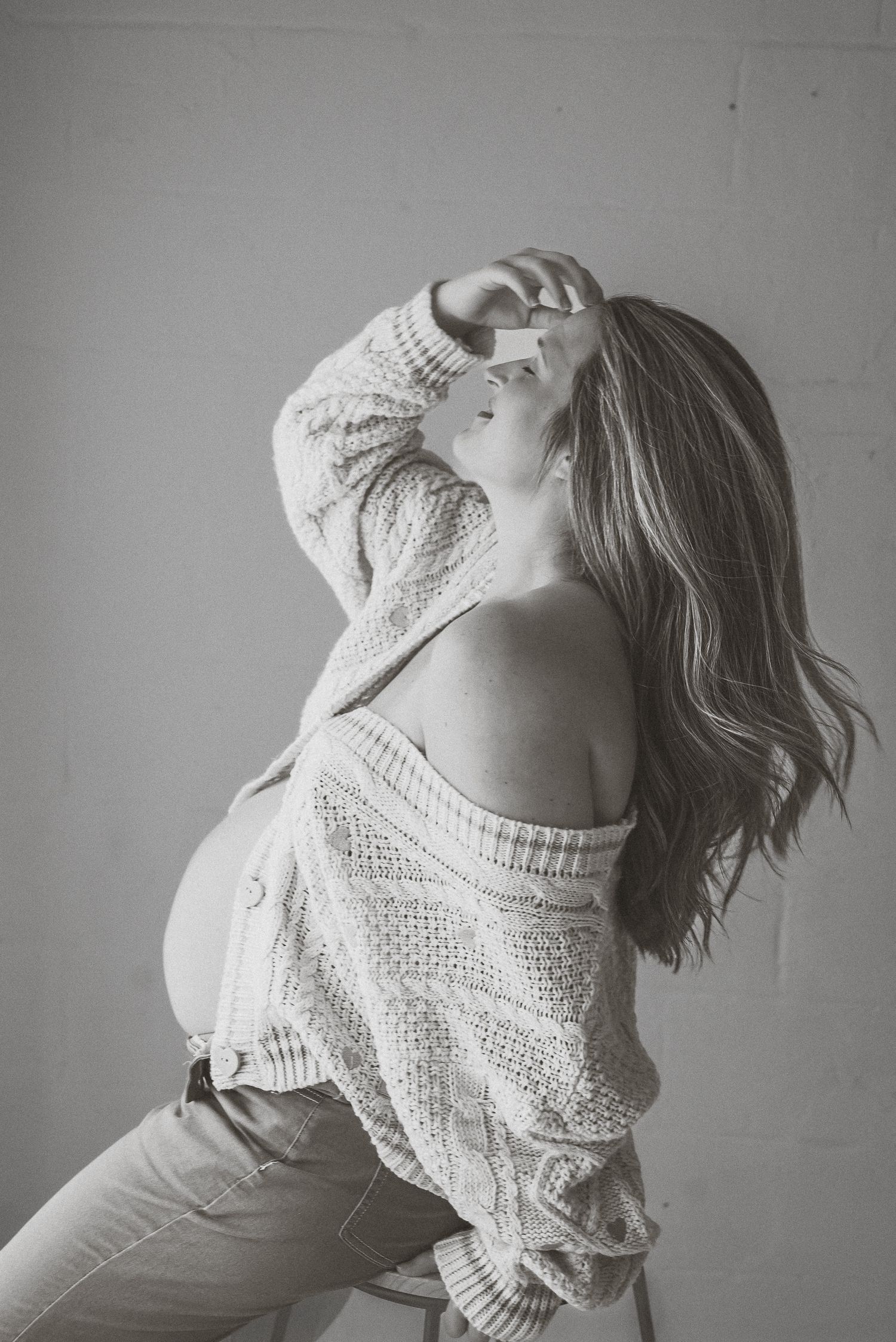 Artistic black and white portrait in textured sweater with dramatic lighting.