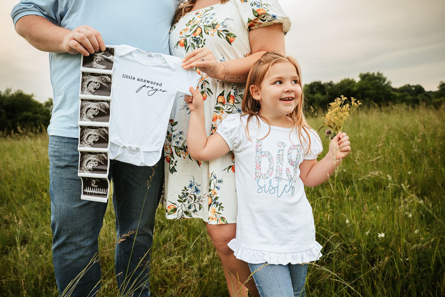 Joyful pregnancy announcement series with ultrasound photos in a wildflower meadow.