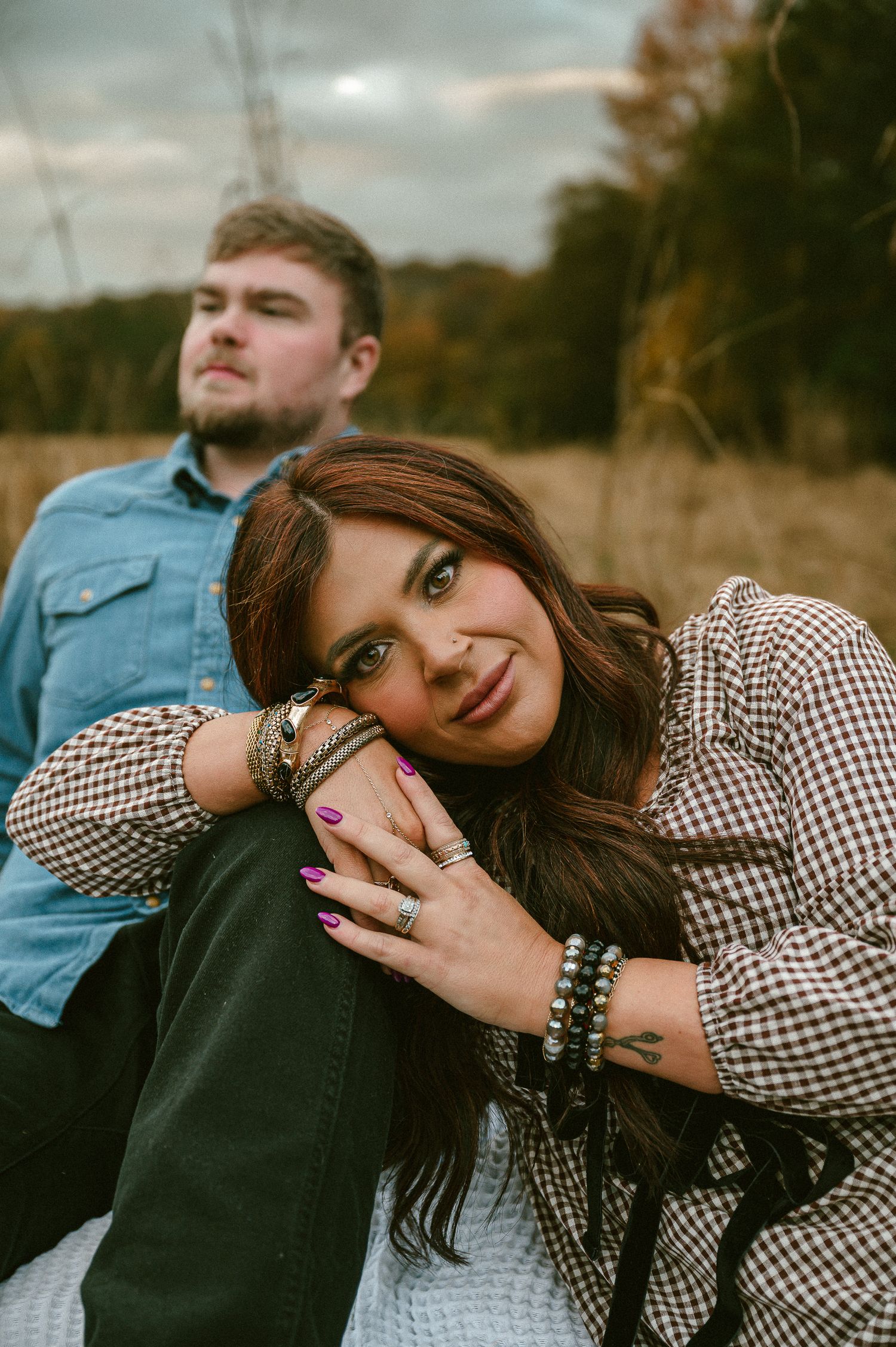 Couple poses together outdoors during autumn sunset photoshoot.