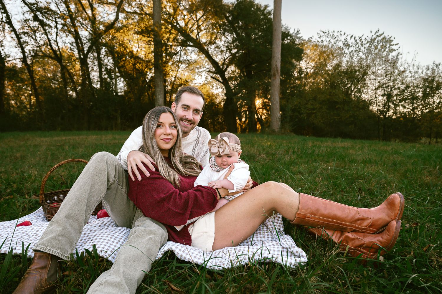Relaxed family portrait session in a grassy field at sunset.