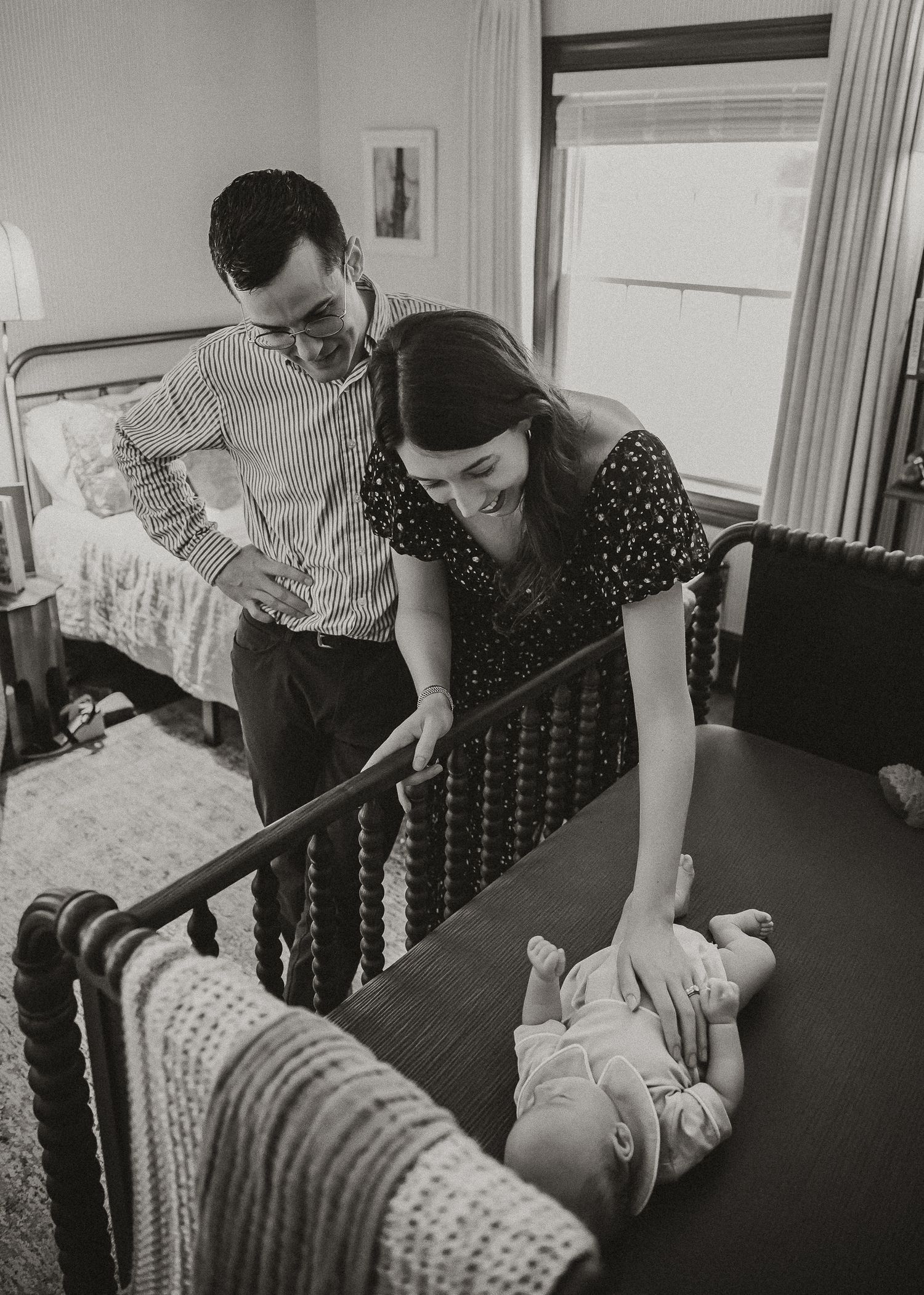 Black and white photo series showing tender moments between parent and baby on a couch.