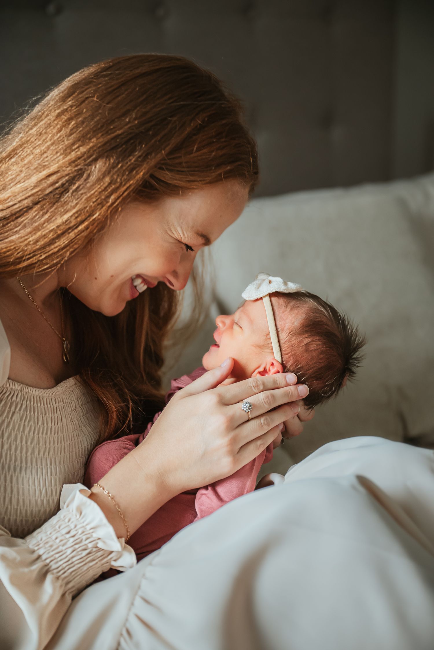 A tender moment between parent and newborn baby in soft natural lighting.