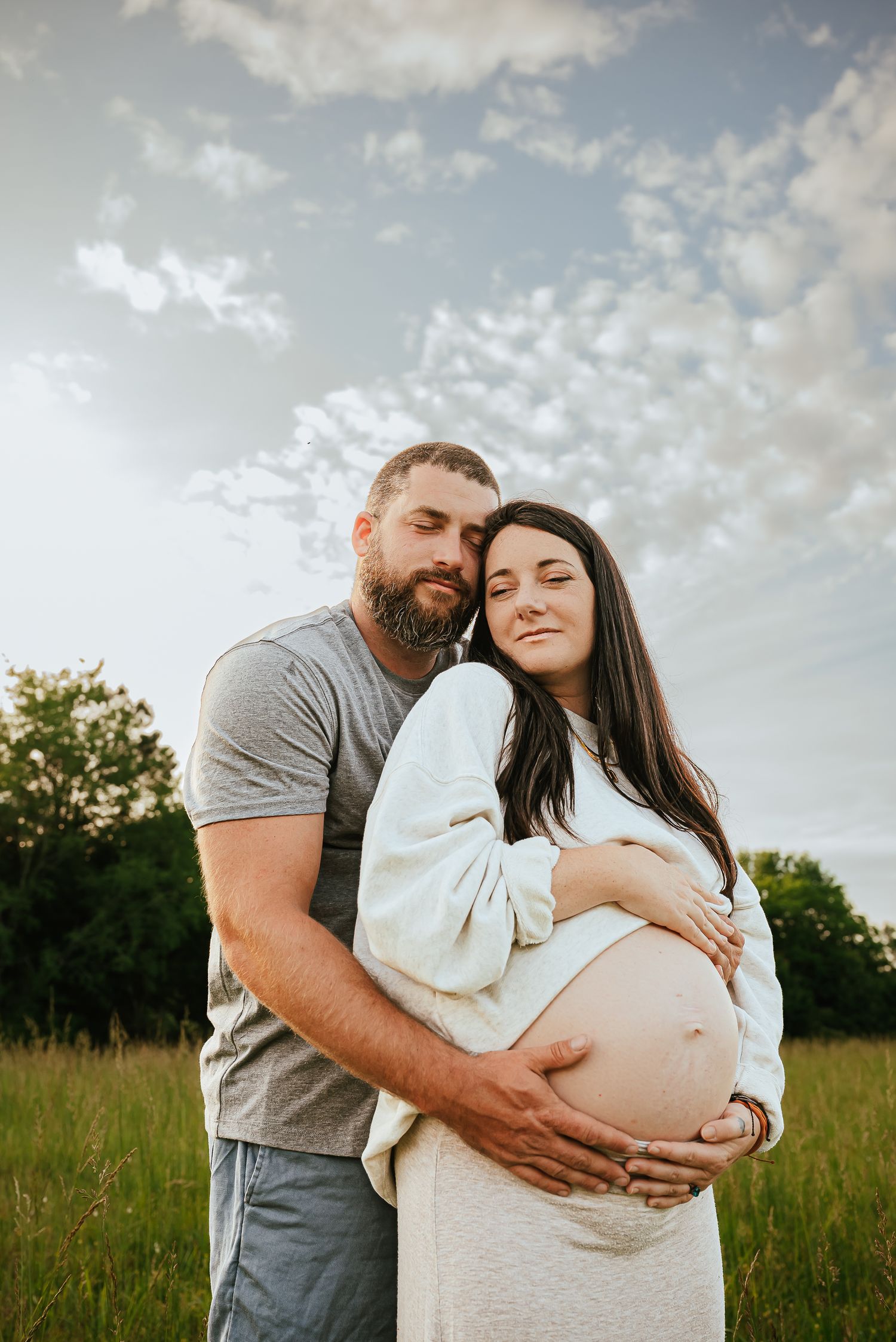 Maternity photoshoot in a golden field during sunset.