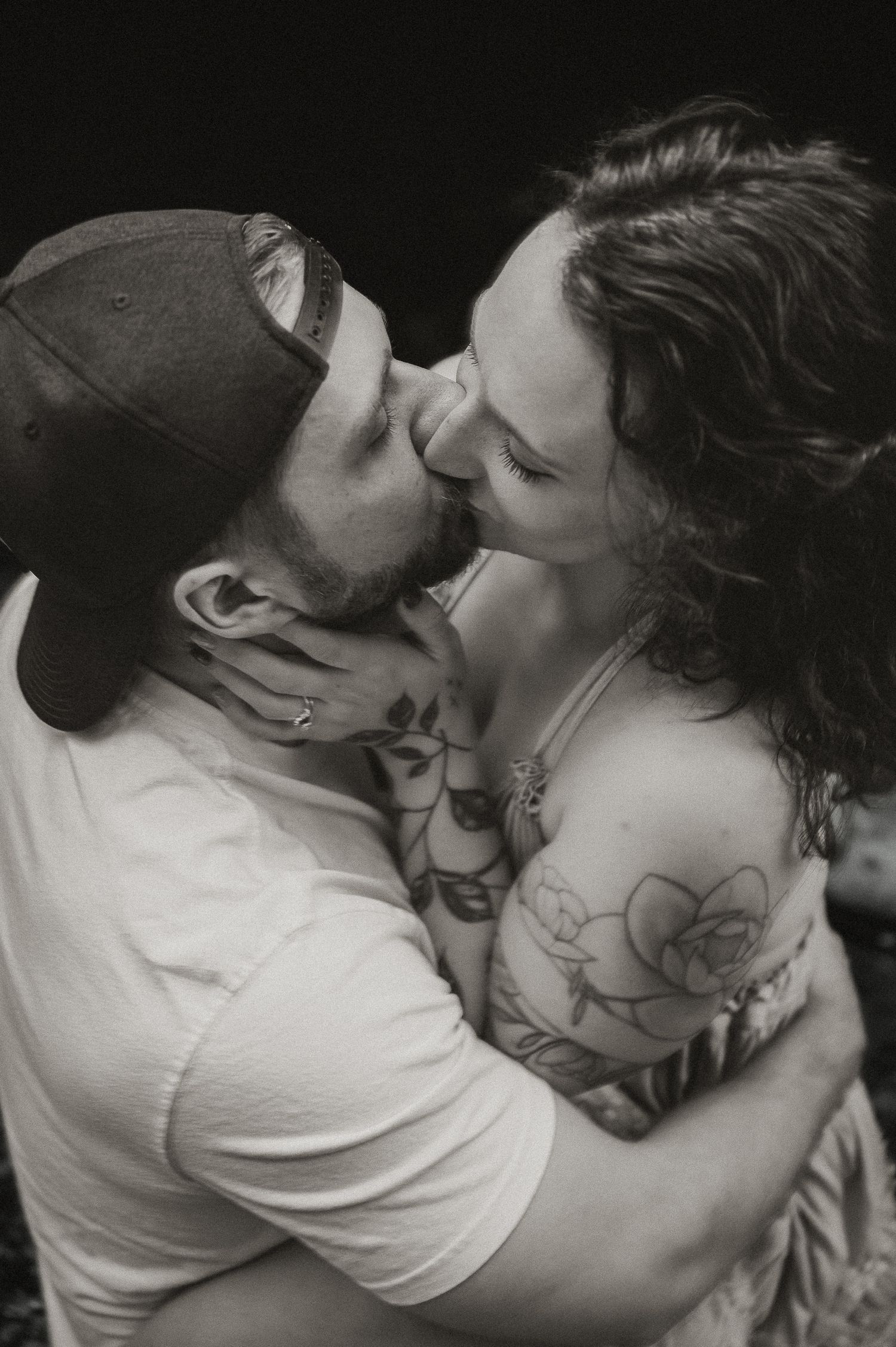 Intimate black and white portrait of couple sharing tender embrace.
