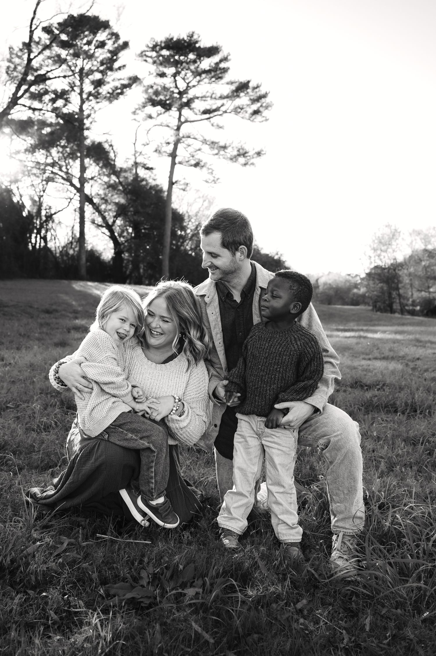 Black and white series of playful family interactions in an outdoor setting.