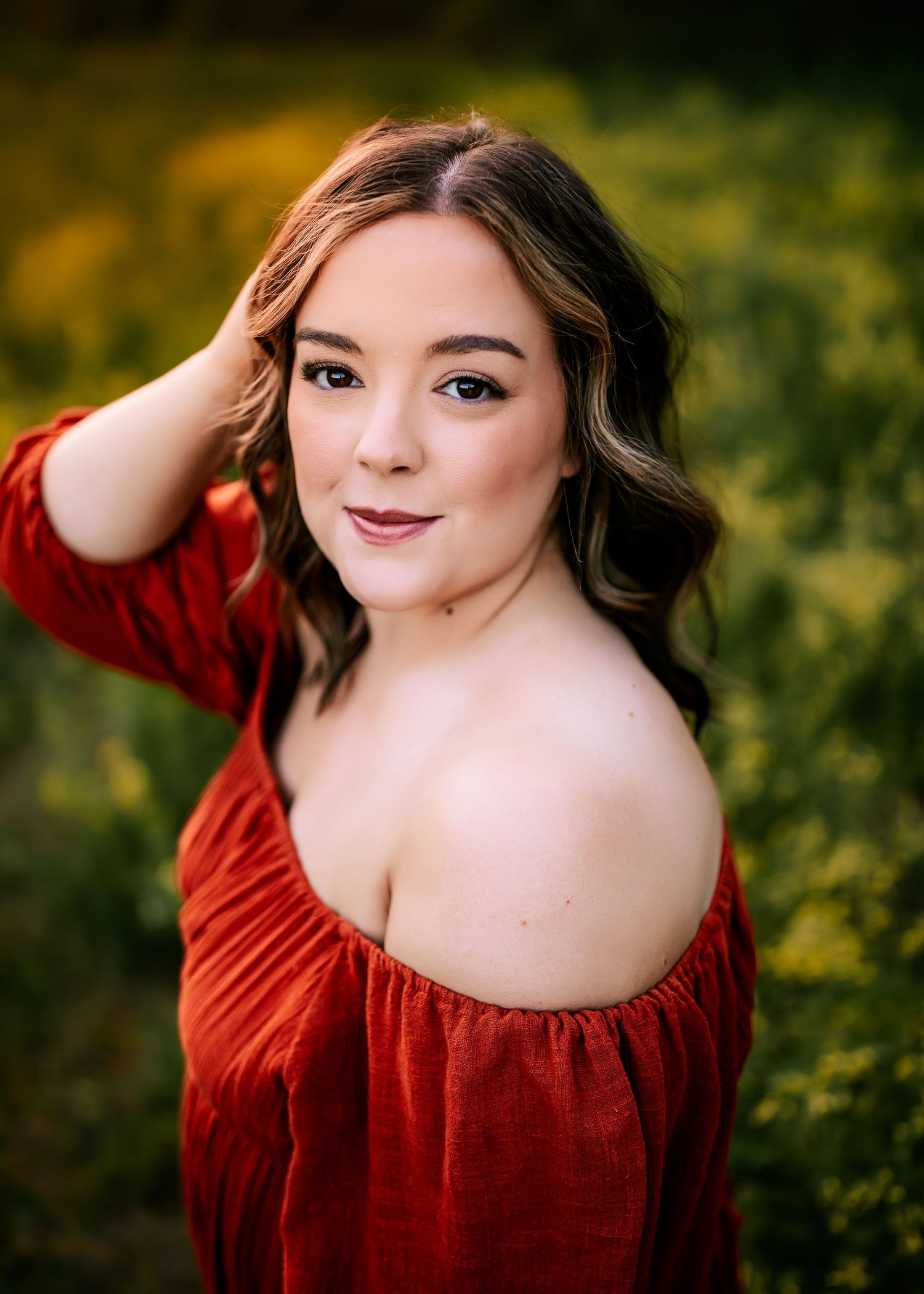 Portrait in red dress against blurred autumn background.