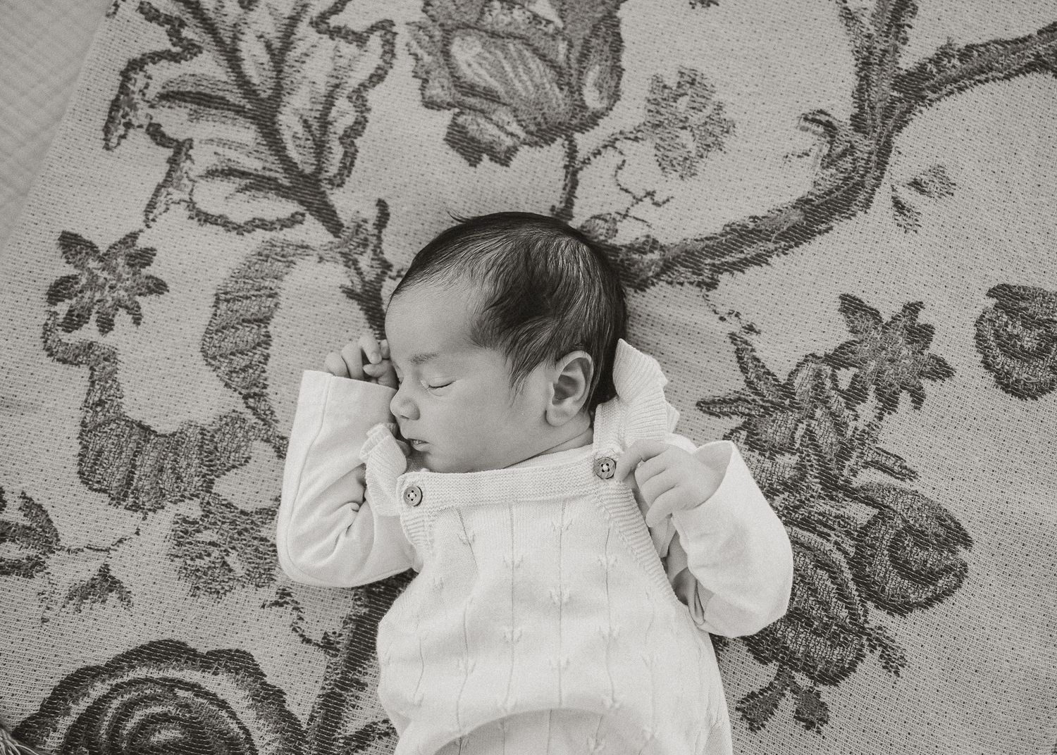 Close-up shots of a sleeping newborn baby against floral patterned fabric.