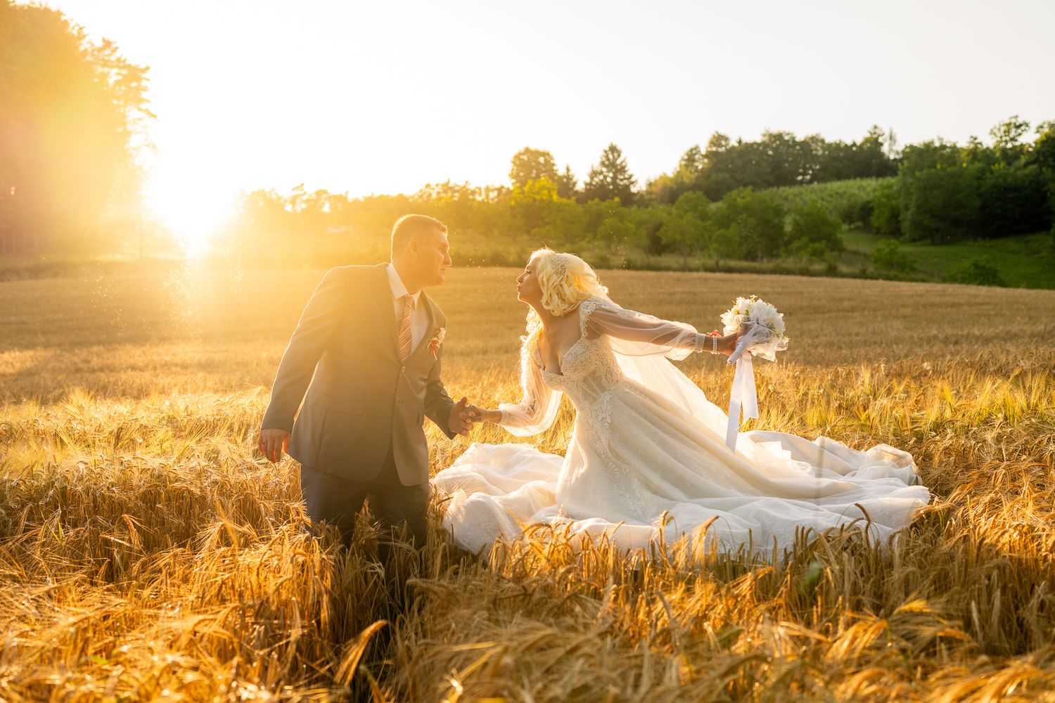Sunset wedding photography session in a golden wheat field with warm backlighting.