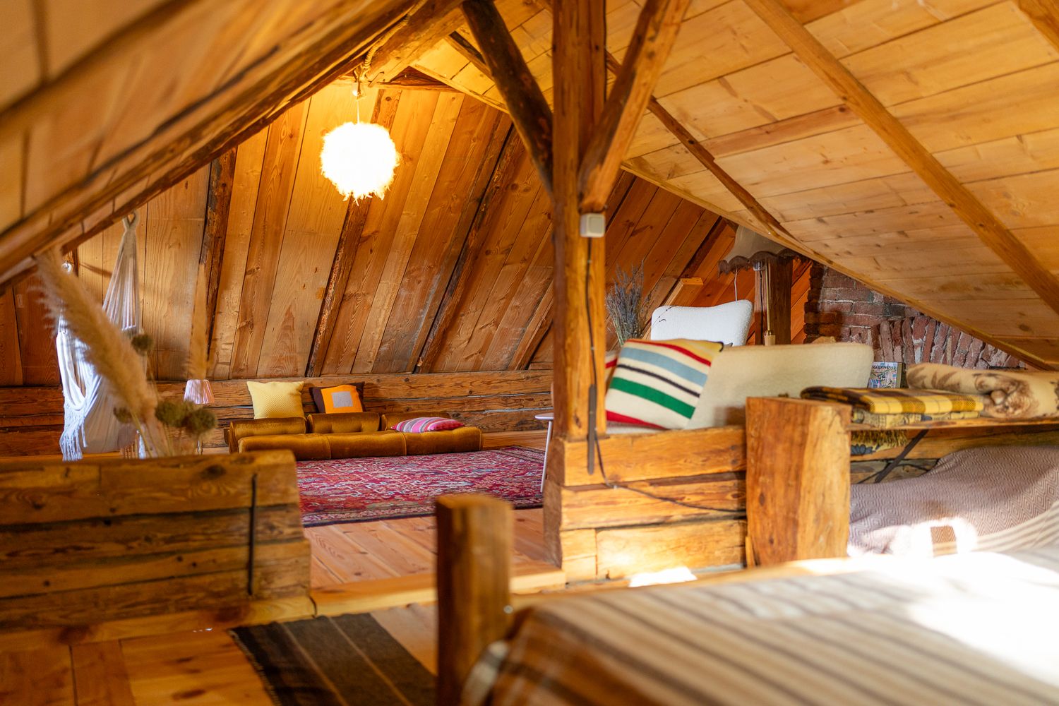 Spacious attic living space with exposed wooden beams and natural lighting.
