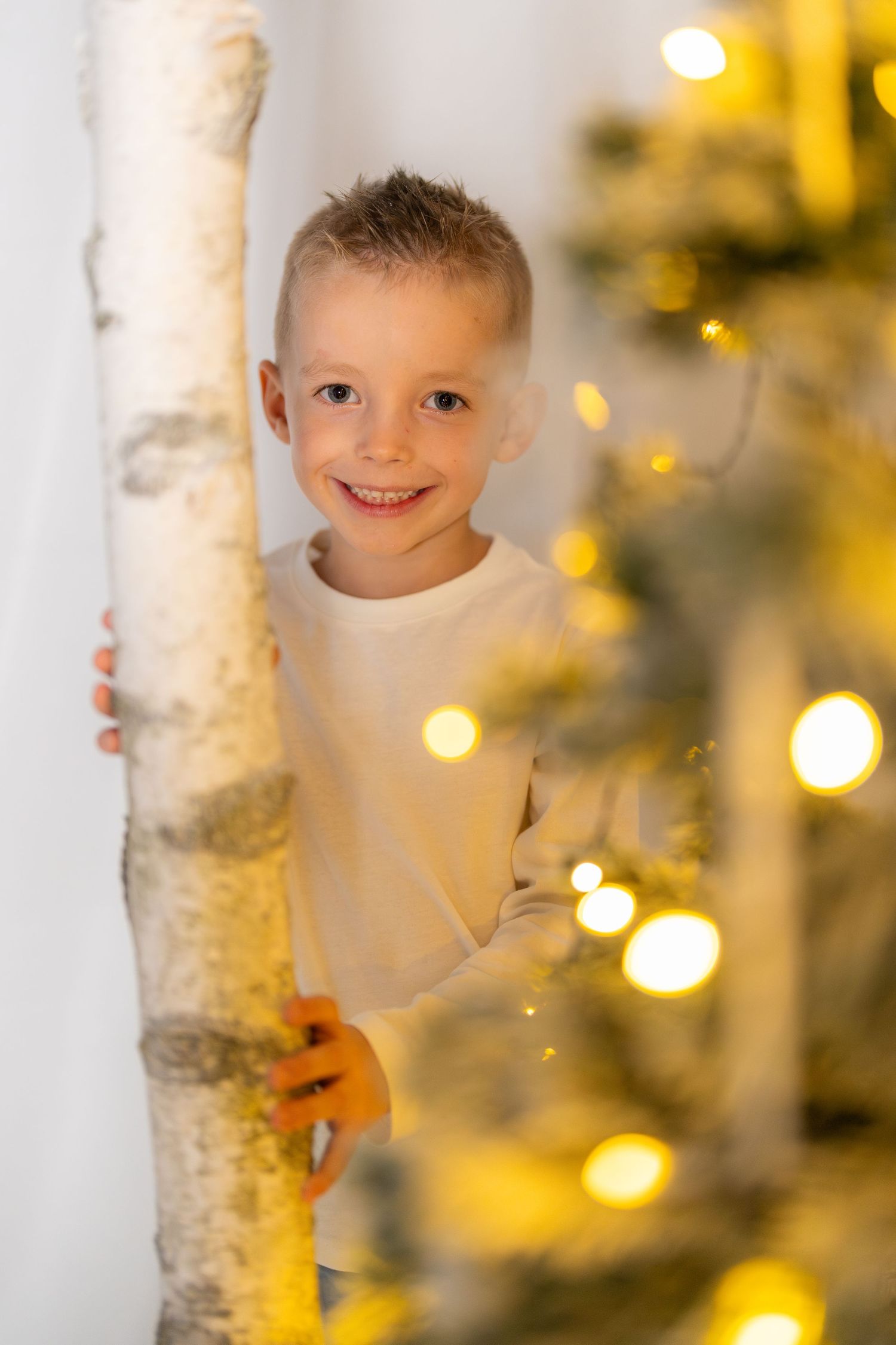 Festive portrait session with birch trees and twinkling holiday lights.