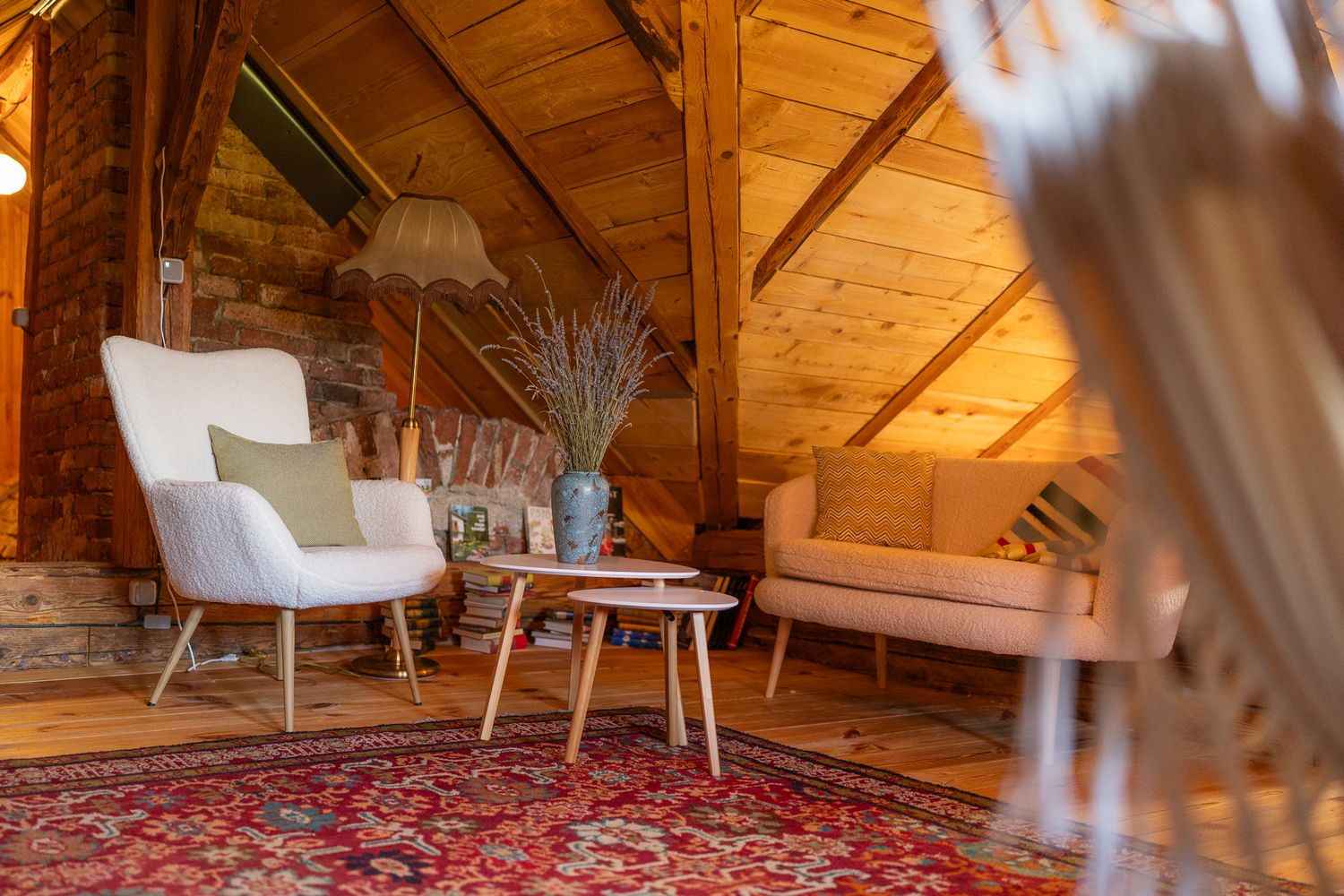 Rustic loft bedroom with wooden ceiling beams and comfortable bedding.