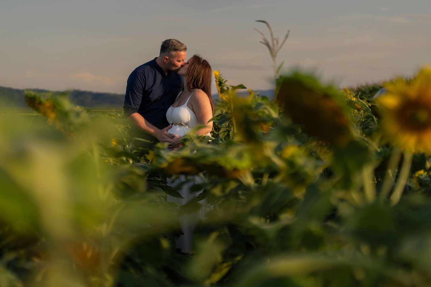 Intimate moment captured in a field during golden hour.