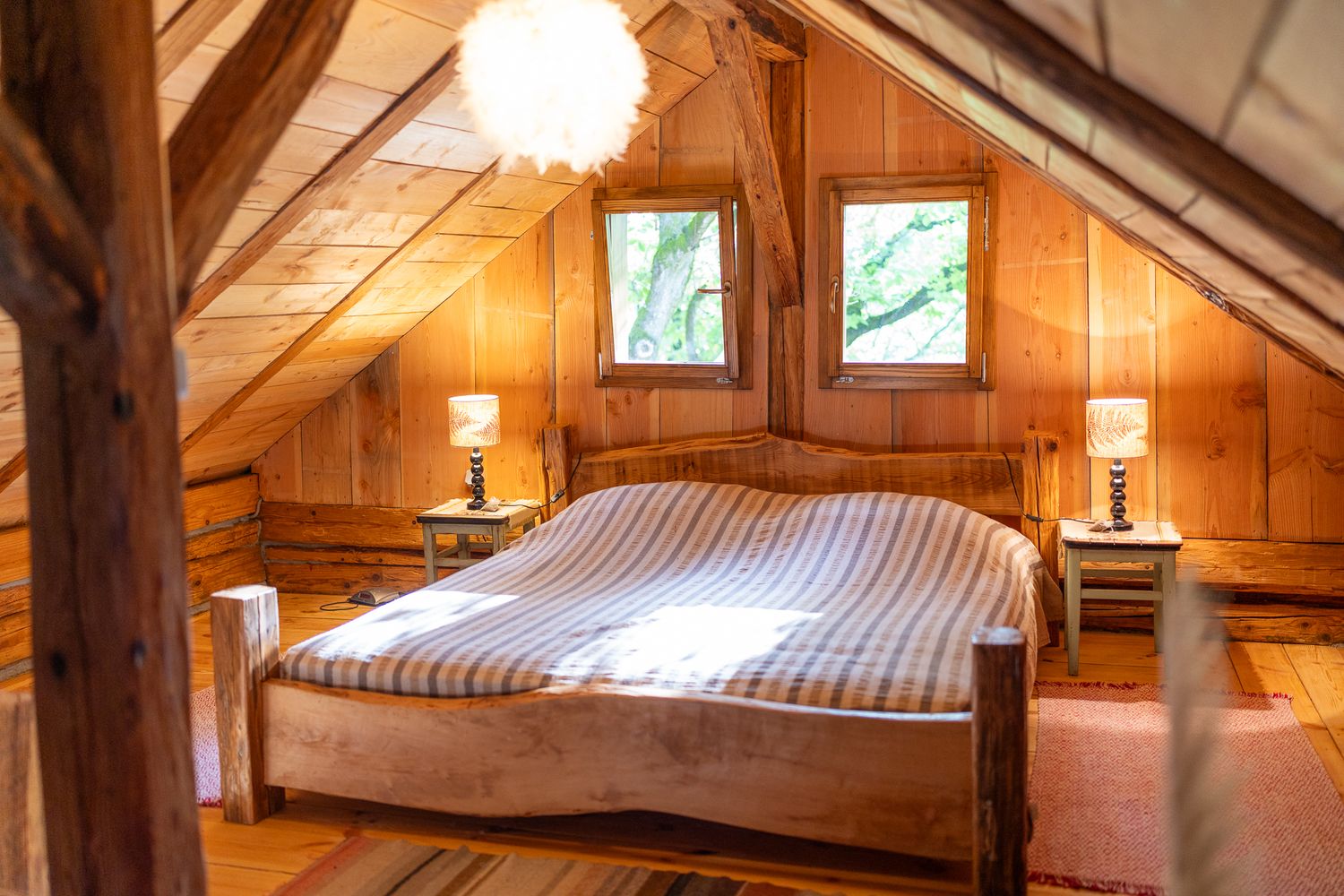 Cozy attic bedroom with wooden beams and soft lighting creating warm ambiance.