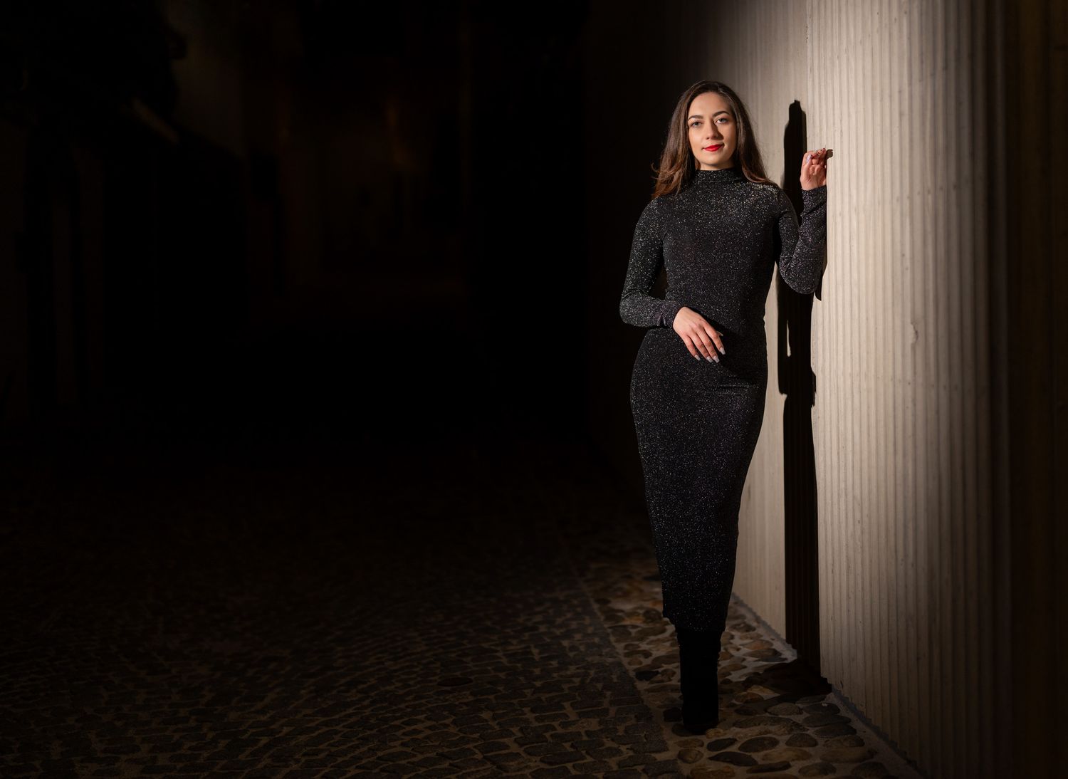 Moody portrait series with architectural columns and dramatic lighting creating depth.