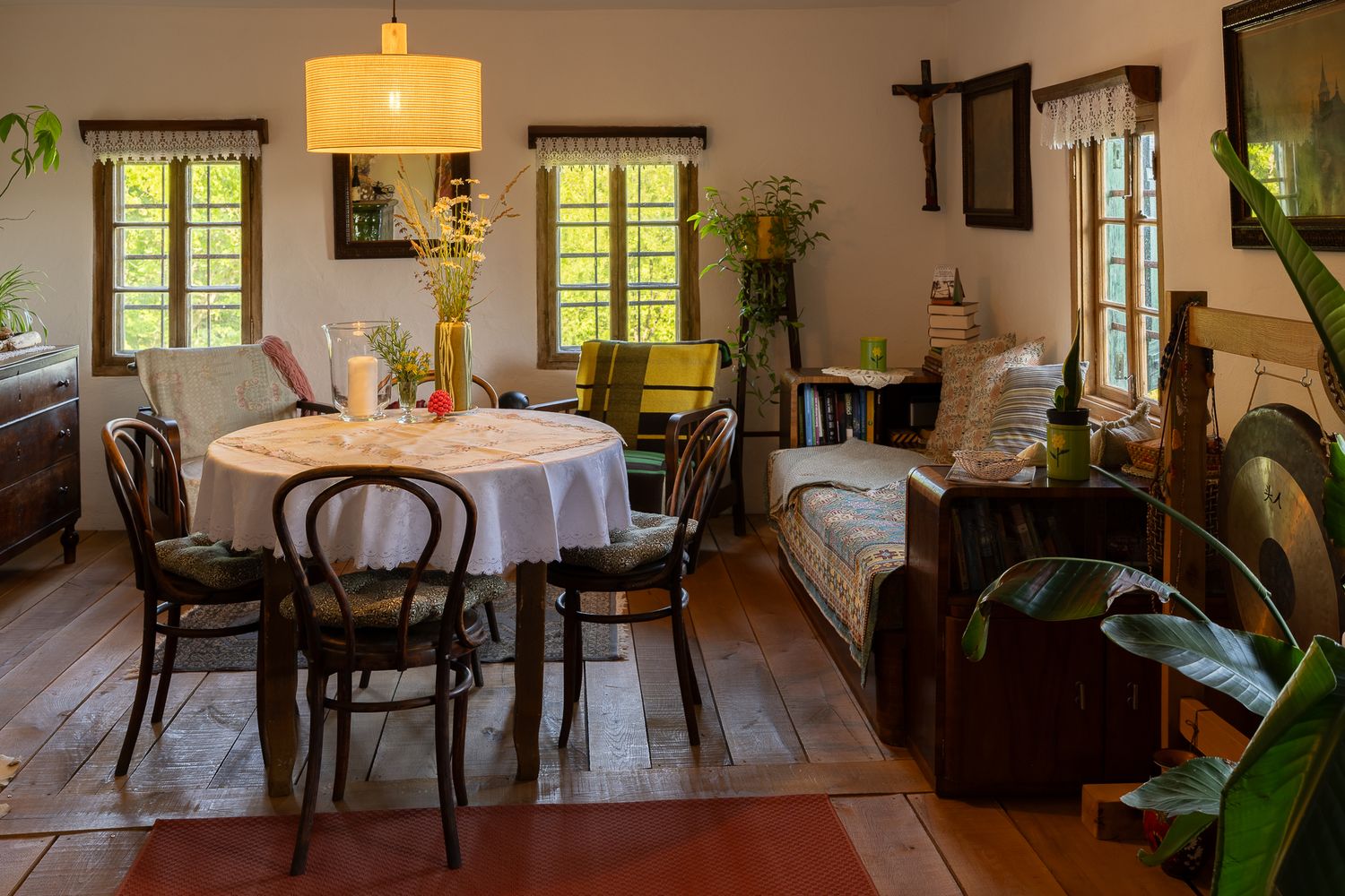 Elegant dining room with large windows, wooden floors, and classic furniture arrangement.