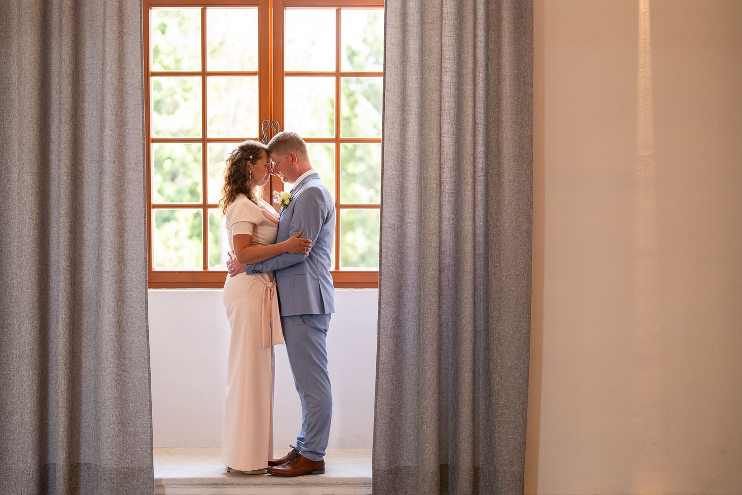 Romantic window light illuminates a couple in an intimate indoor setting.