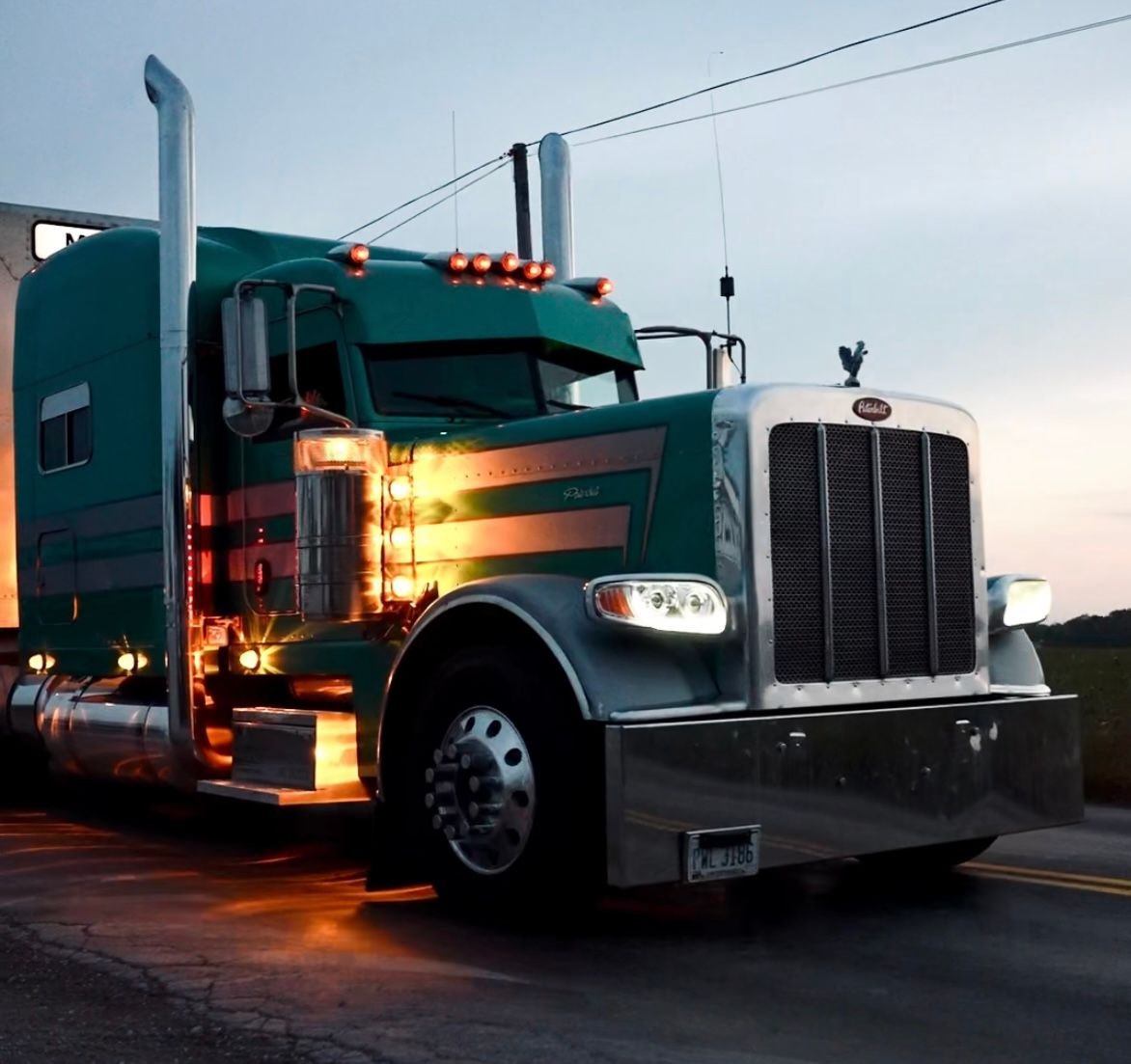 A green Peterbilt semi truck with a cattle pot