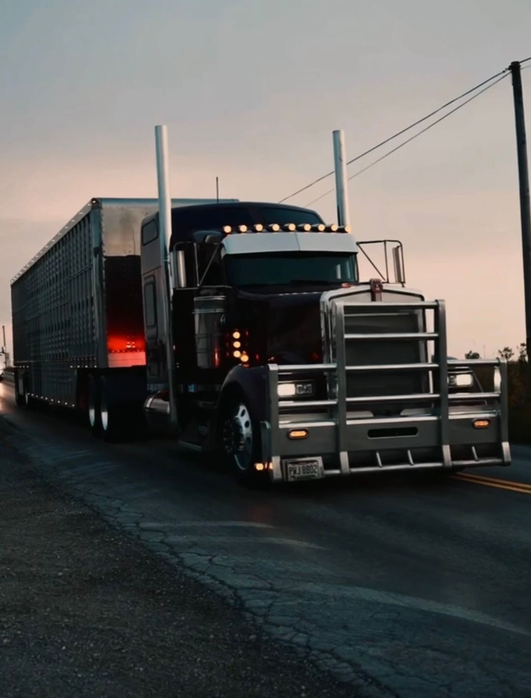 A maroon Kenworth semi truck with a cattle pot