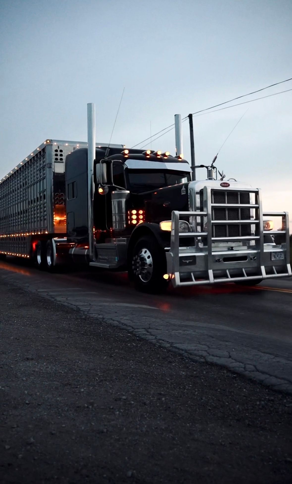 A black Peterbilt semi truck with a cattle pot