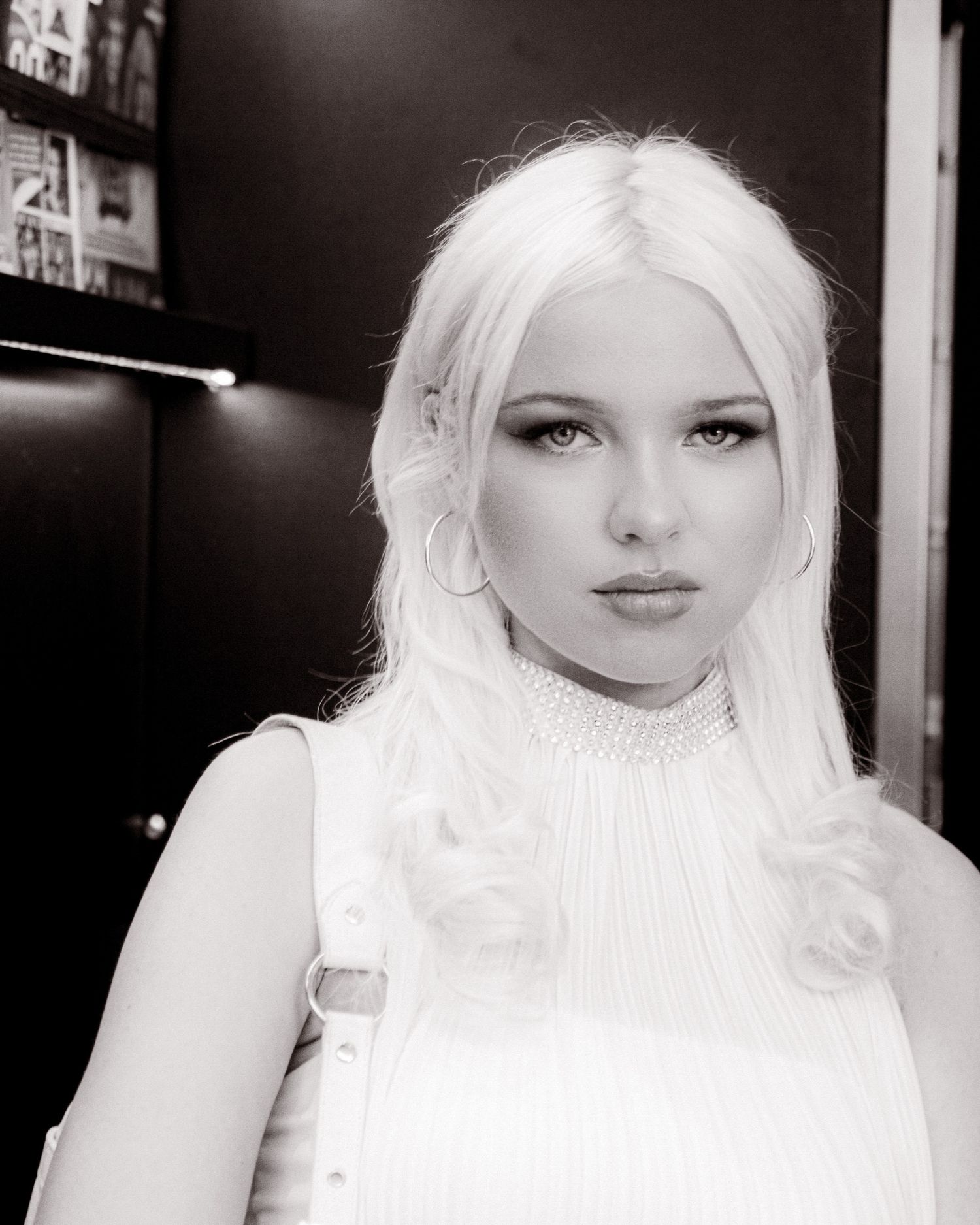 Black and white portrait of a young woman with long platinum blonde hair wearing a white turtleneck top.