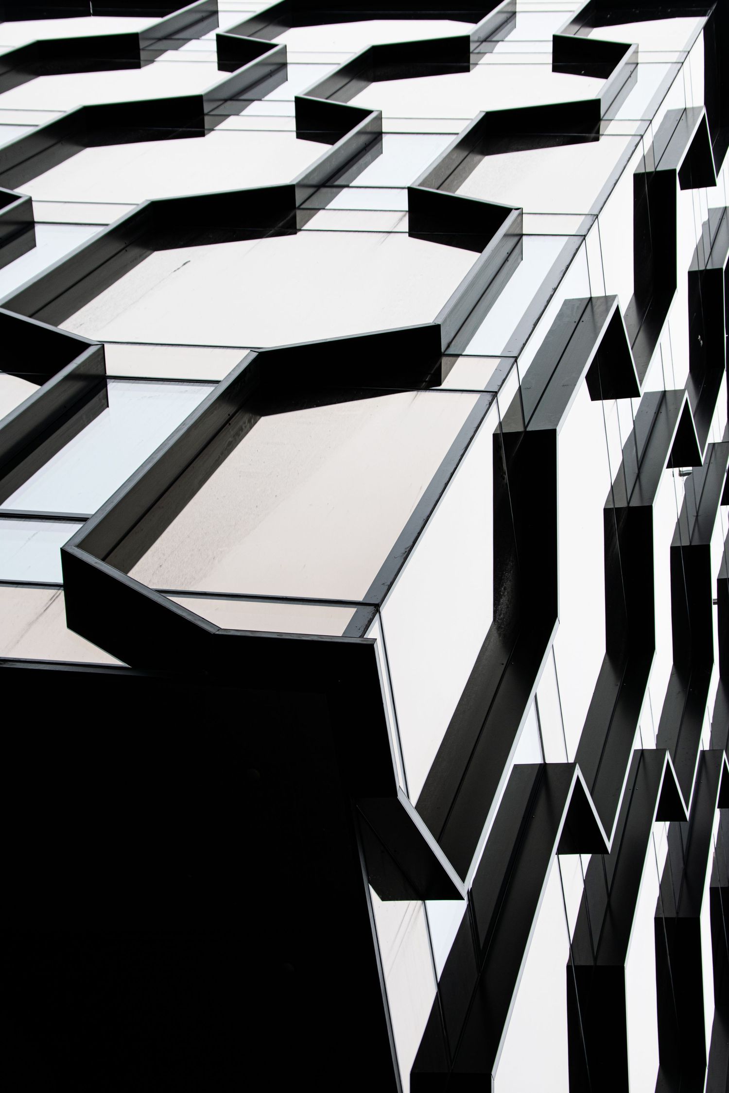Abstract black and white geometric hexagonal pattern on modern building exterior facade architecture detail.