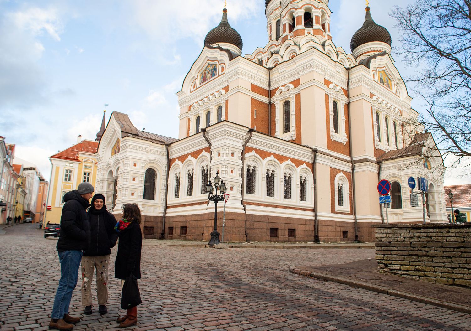 Two people stand in a cobblestone square before the Alexander Nevsky Cathedral in Tallinn, Estonia.