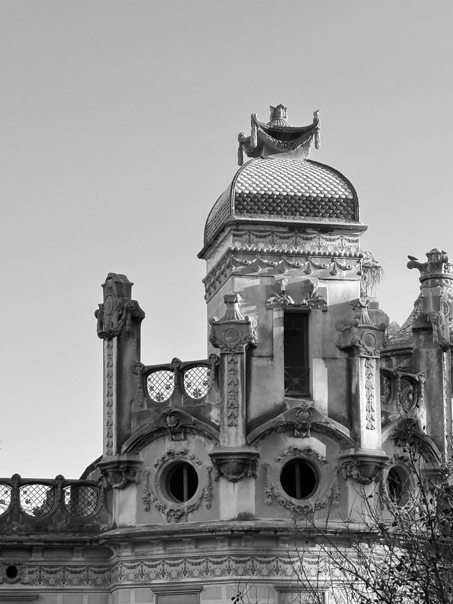 Black and white photo of an ornate historic building dome with intricate carvings, arched windows, and decorative stonework.