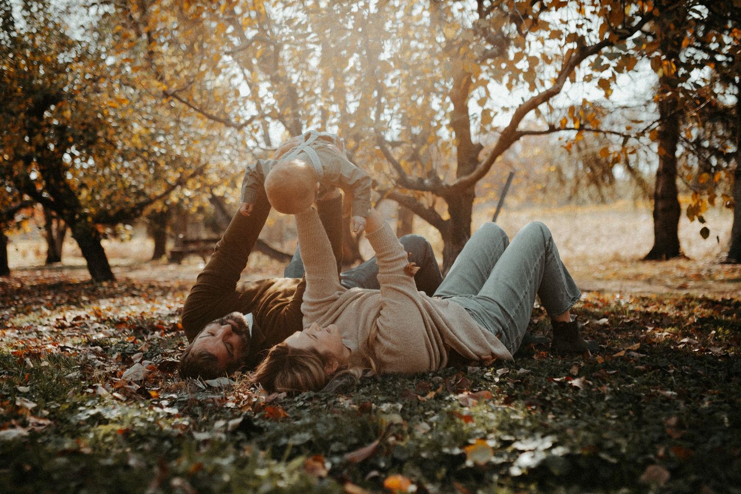 A couple relaxes on fallen autumn leaves during golden hour. Pittsburgh Westmoreland Photographer