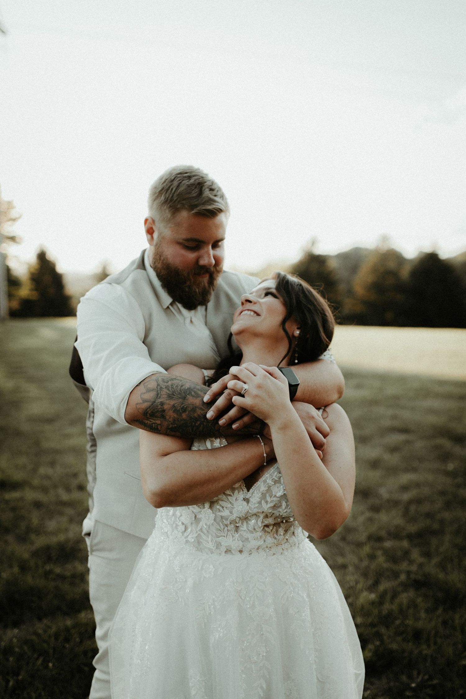 Intimate wedding moment captured as couple laughs together in golden outdoor setting. Pittsburgh Wedding Photographer