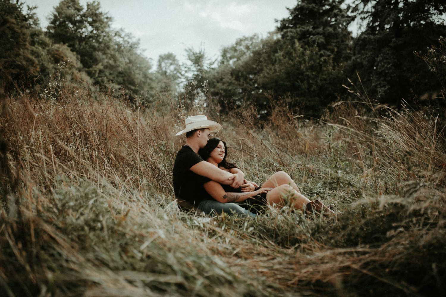 Couple sharing intimate moment while sitting in tall autumn grass. Pittsburgh Wedding Photographer