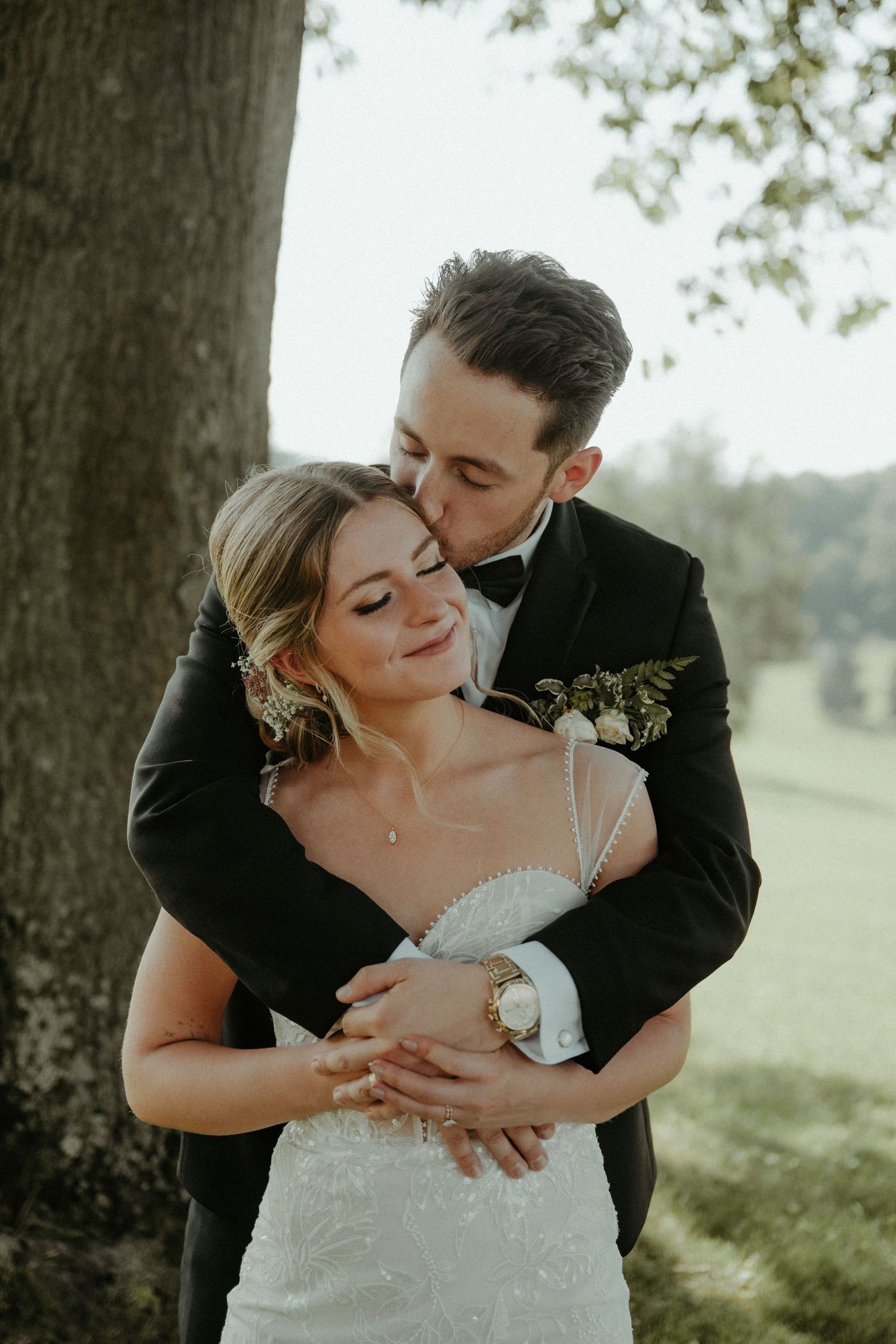 A romantic wedding portrait series shows close-up moments between newlyweds in an outdoor setting with sunlit trees.
