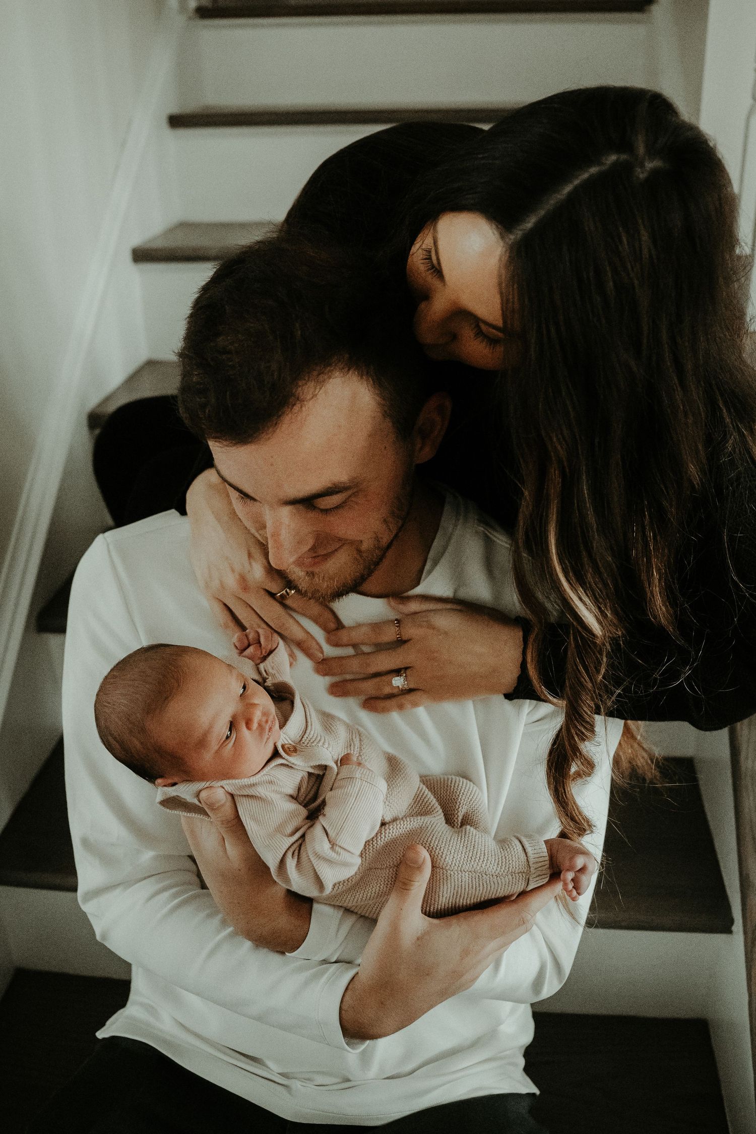 Tender family moment with newborn baby on stairs in intimate indoor setting. Pittsburgh Westmoreland Photographer