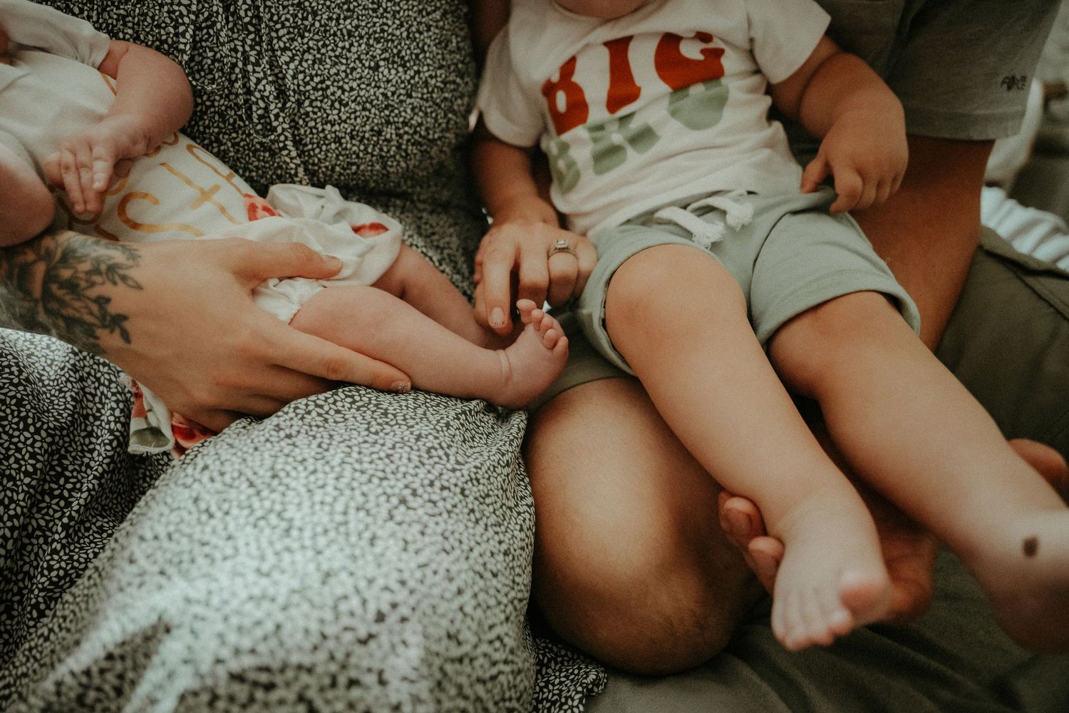 Bare feet and legs resting on a gray speckled couch with someone wearing shorts and a white t-shirt. Pittsburgh / Westmoreland Photographer