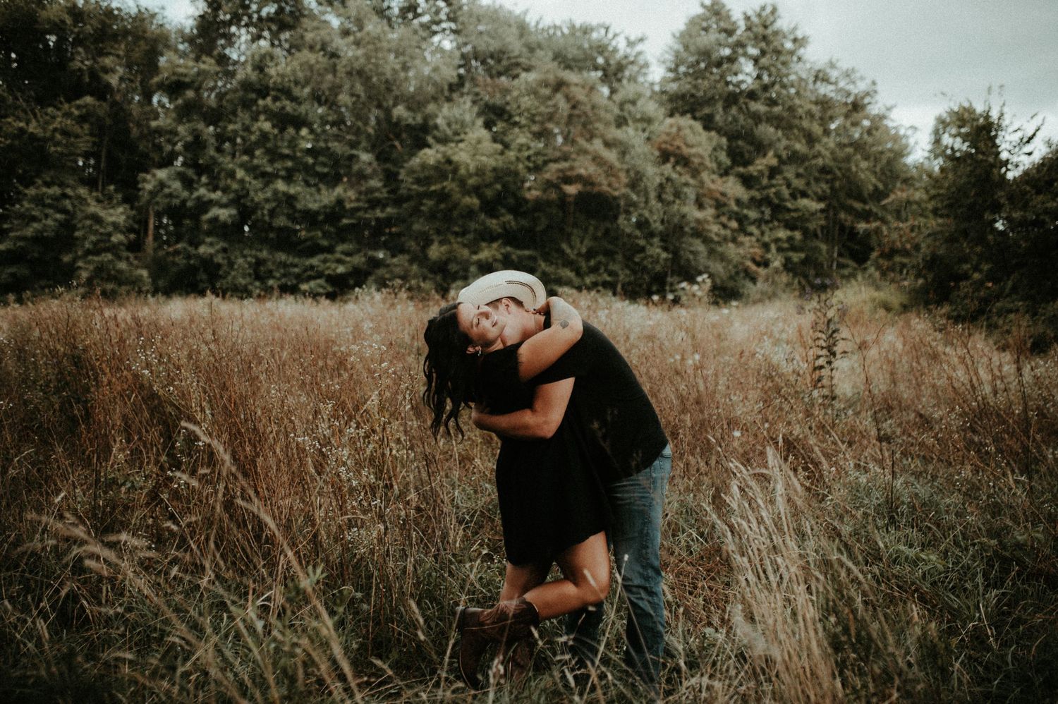 A playful couple embracing in a field of tall autumn grass at sunset. Pittsburgh Wedding Photographer