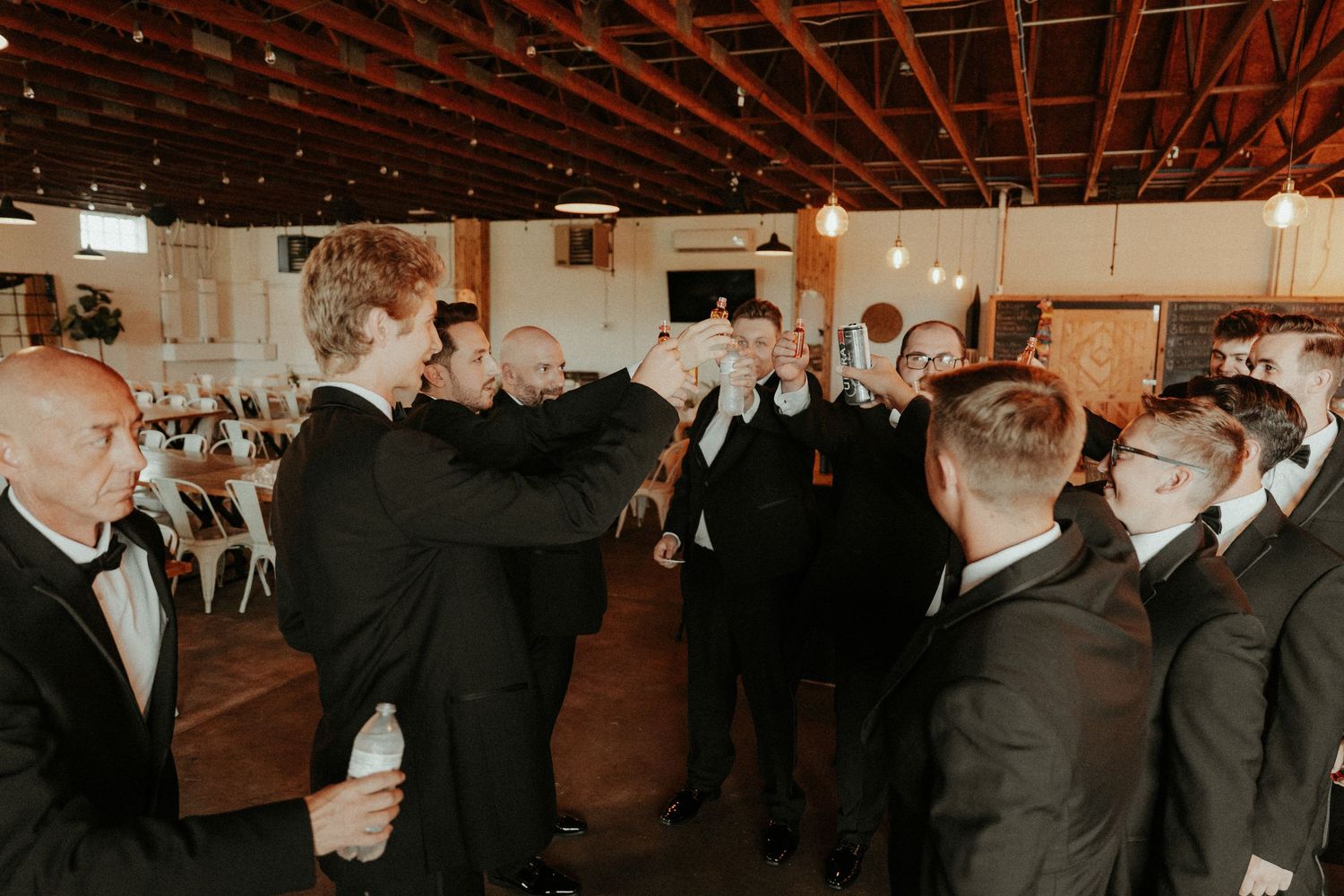 A group of men in formal black suits and ties dance in formation at a wedding reception. Pittsburgh Wedding Photographer