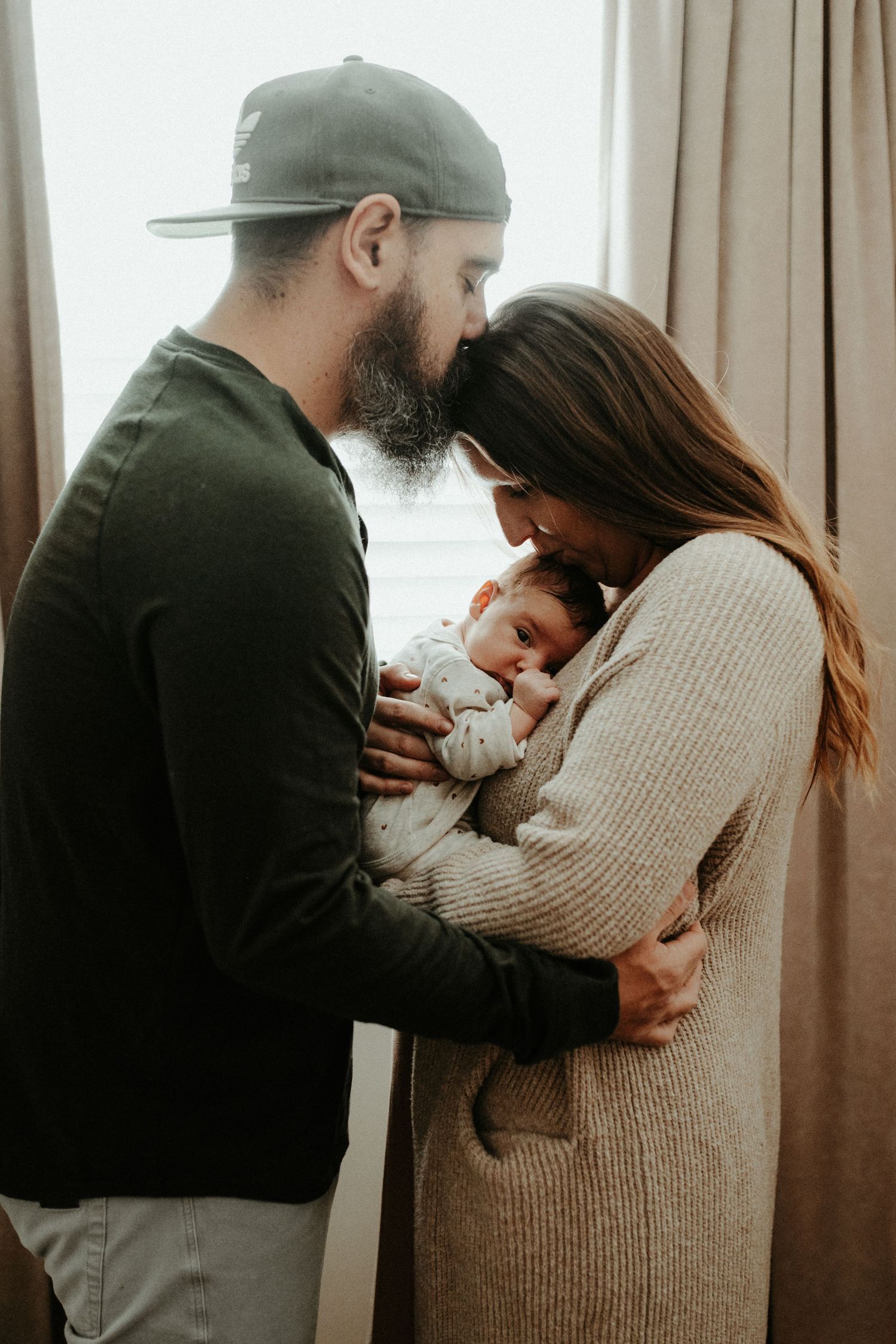 A loving couple embraces their newborn baby in a tender moment. Pittsburgh / Westmoreland Photographer