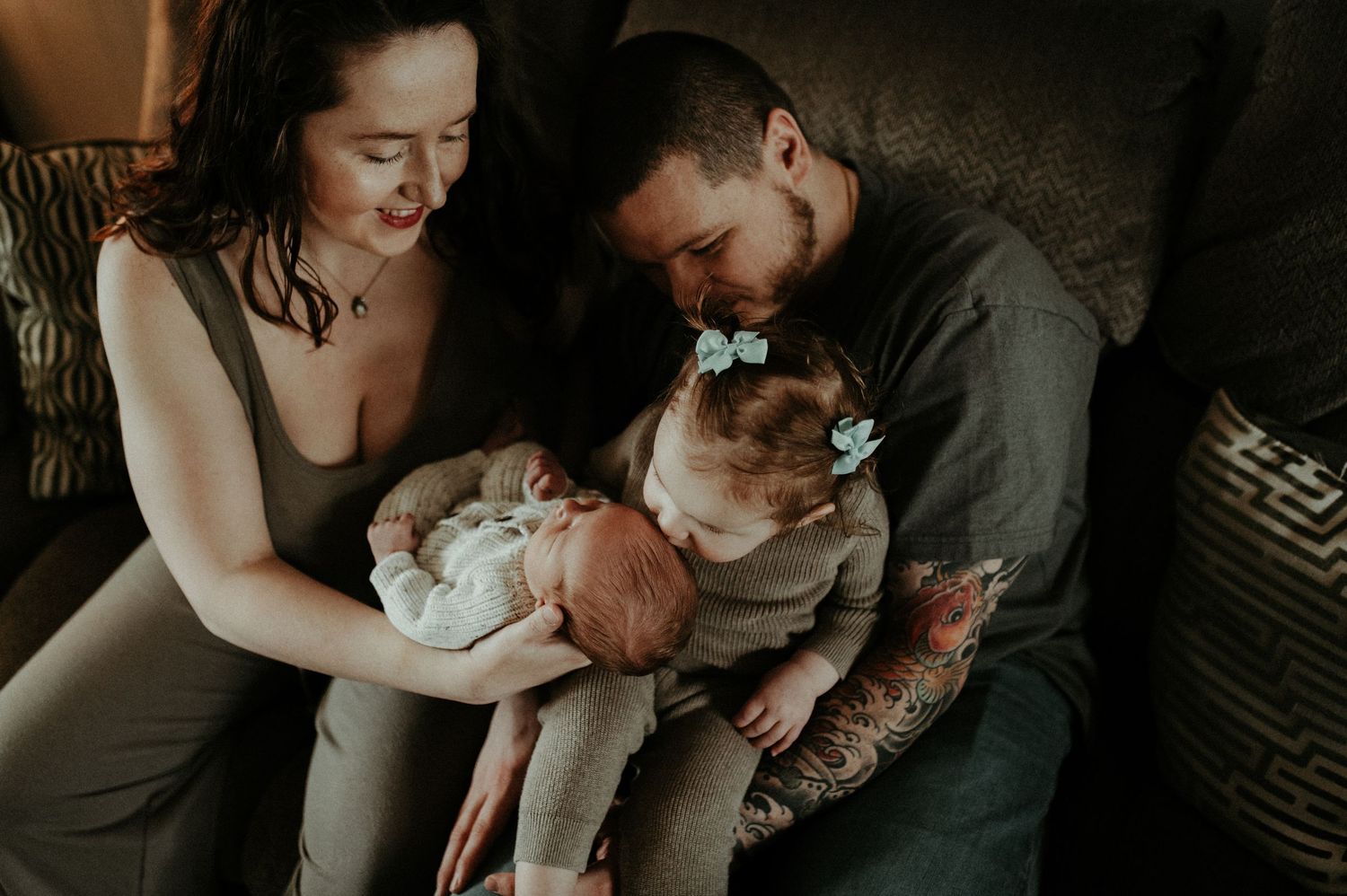 Couple bonding with their newborn baby and siamese cat in a dimly lit room. Pittsburgh / Westmoreland Photographer