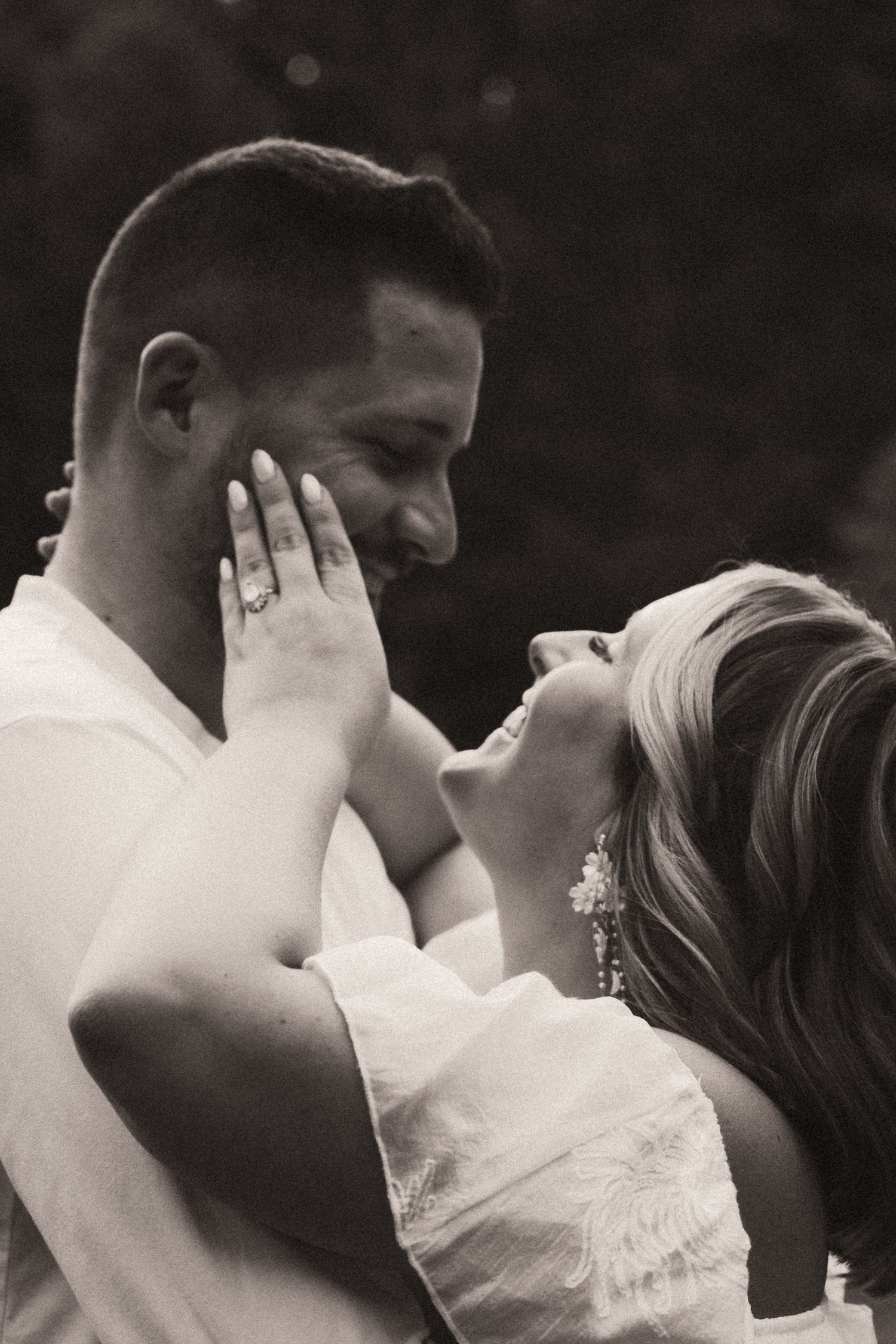 A romantic black and white photo captures an intimate moment between newlyweds sharing a tender embrace. Pittsburgh Wedding Photographer