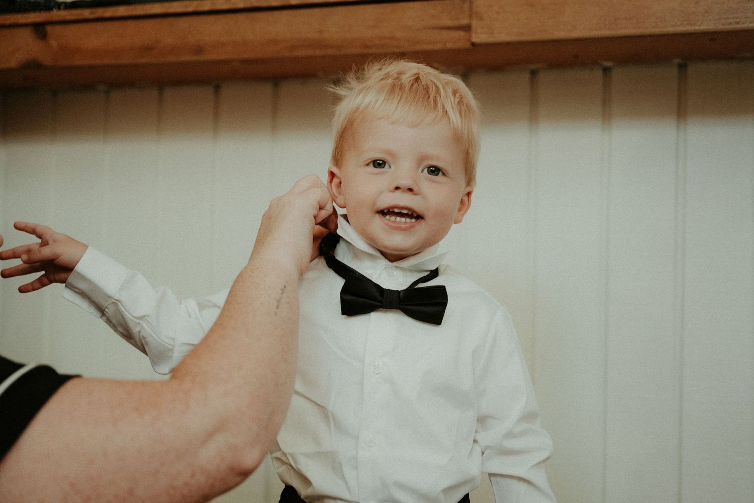A collection of candid black and white wedding moments showing dancing, smiles, and formal attire.