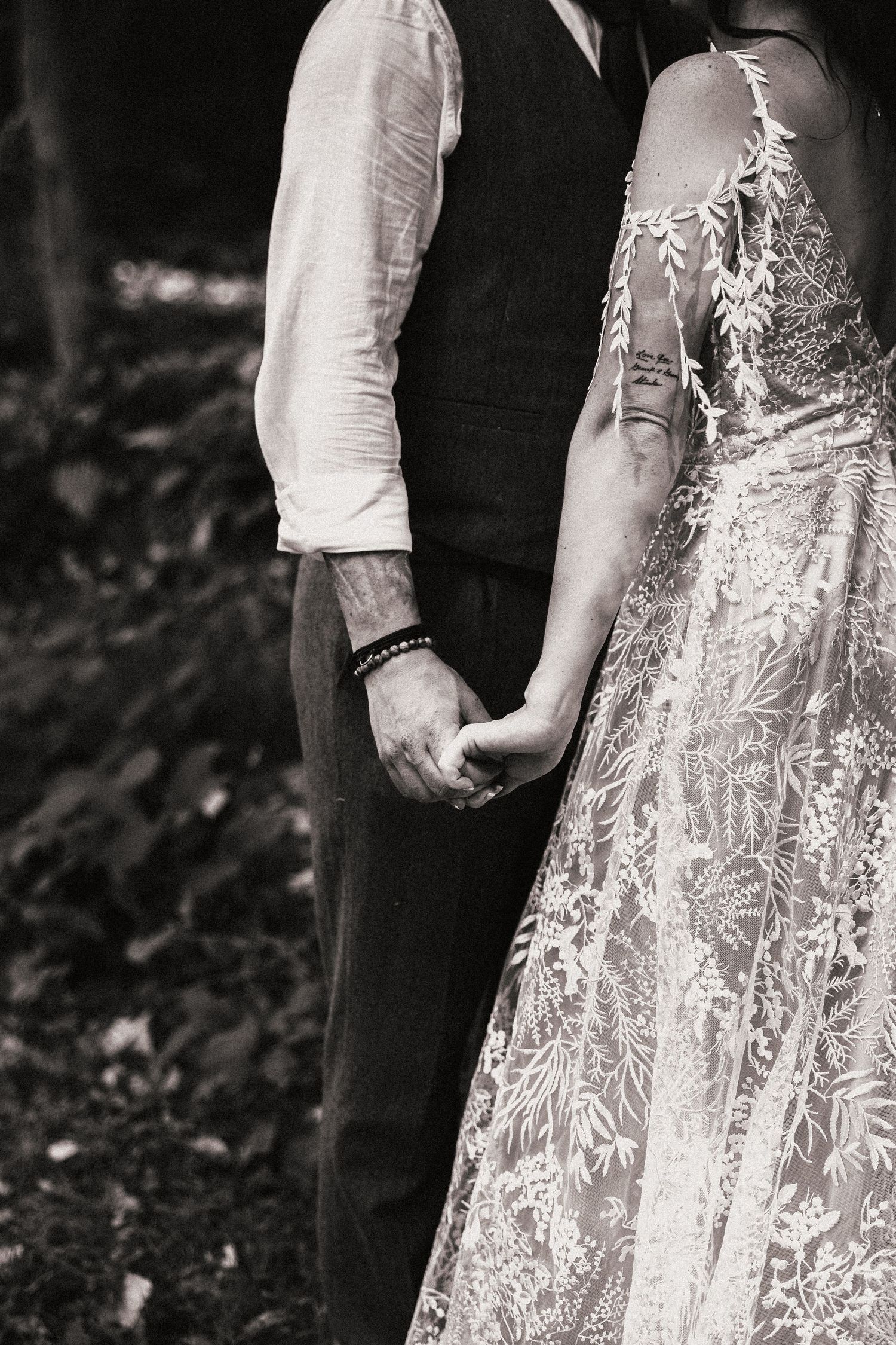 Black and white detail shot of couple holding hands, showcasing intricate lace wedding dress. Pittsburgh Wedding Photographer