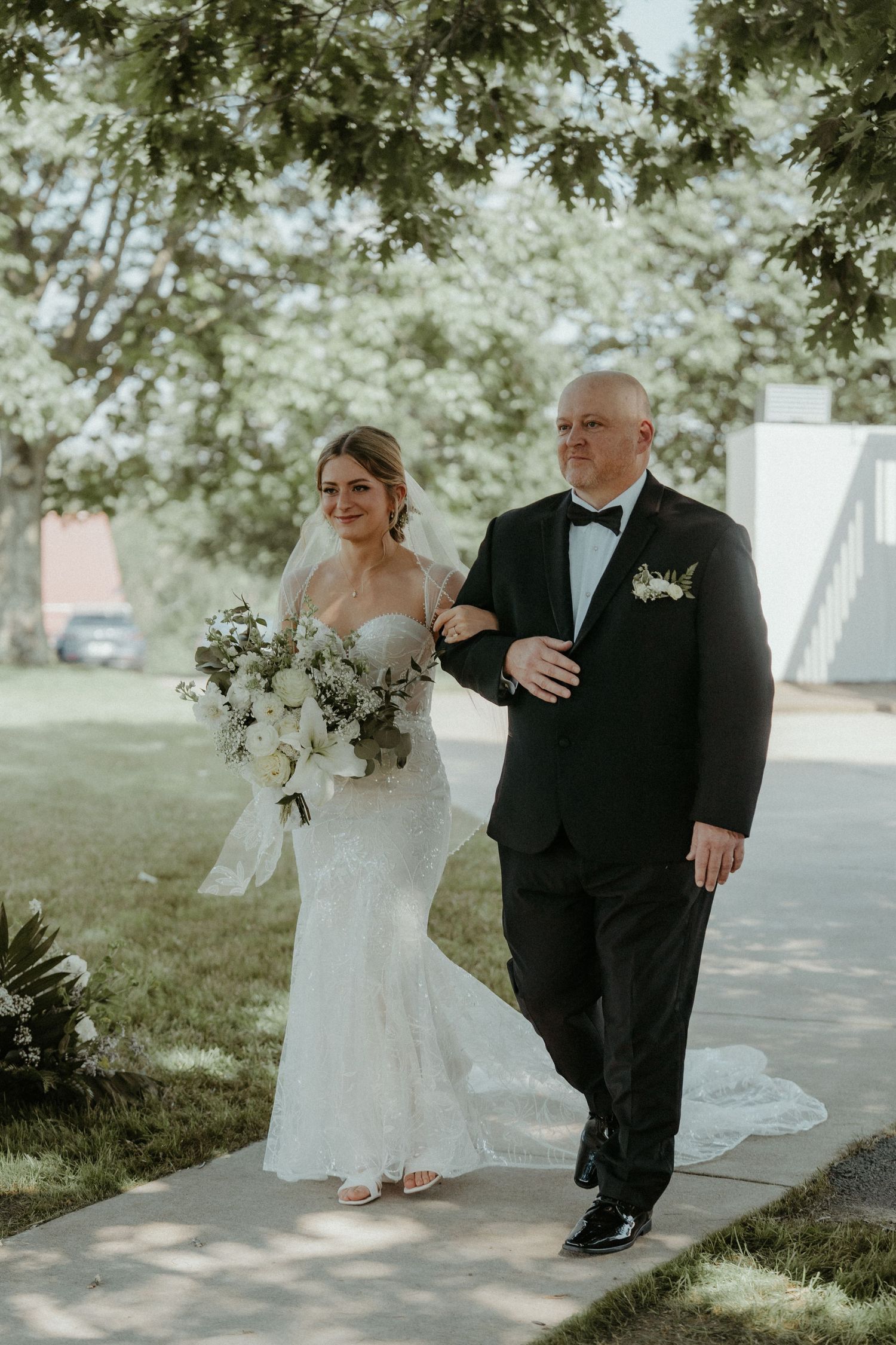 A bride and groom share a tender moment outdoors during their first look wedding photographs under dappled sunlight.
