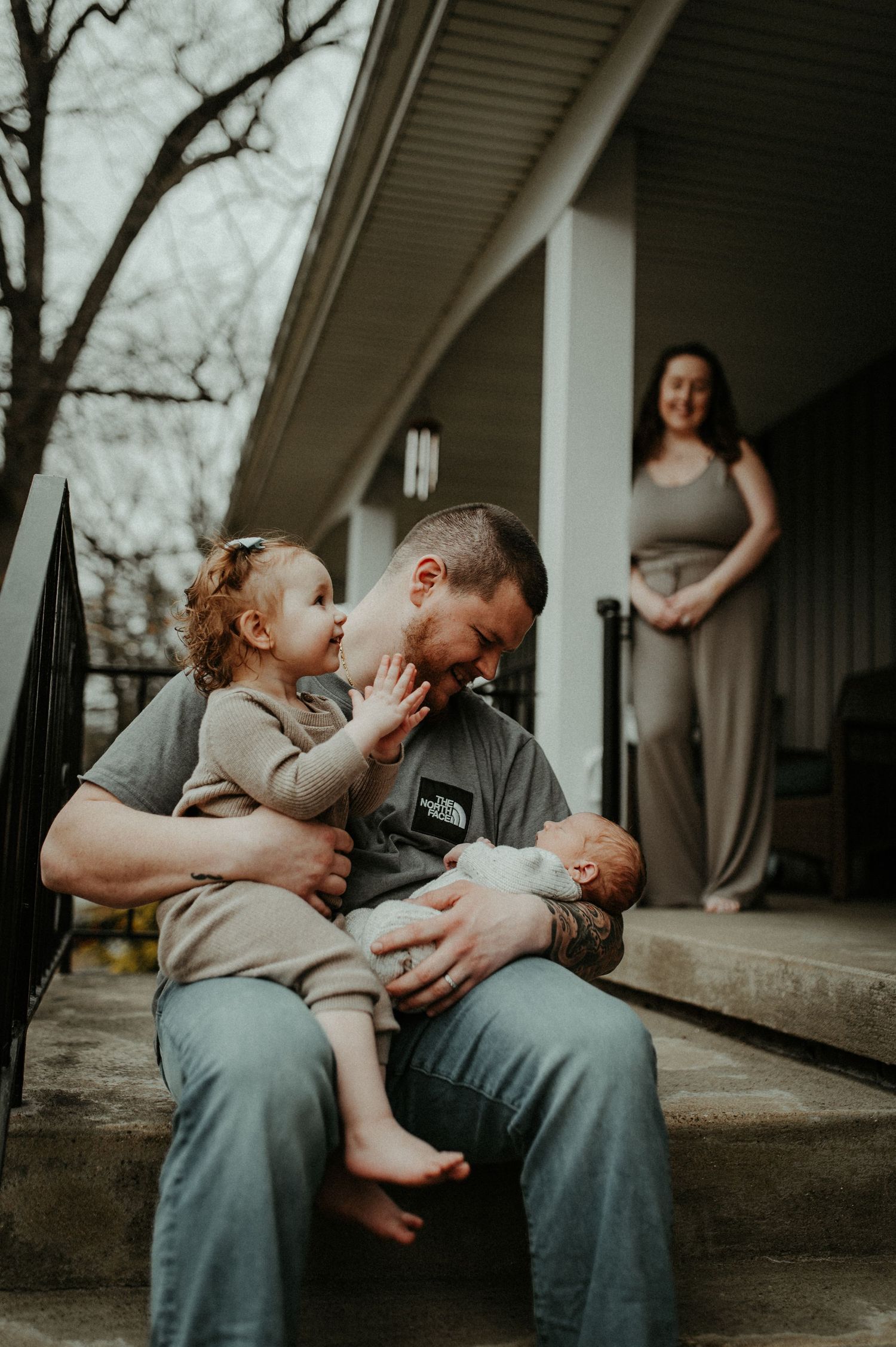 Tender moments between family members sitting on steps at dusk. Pittsburgh / Westmoreland Photographer
