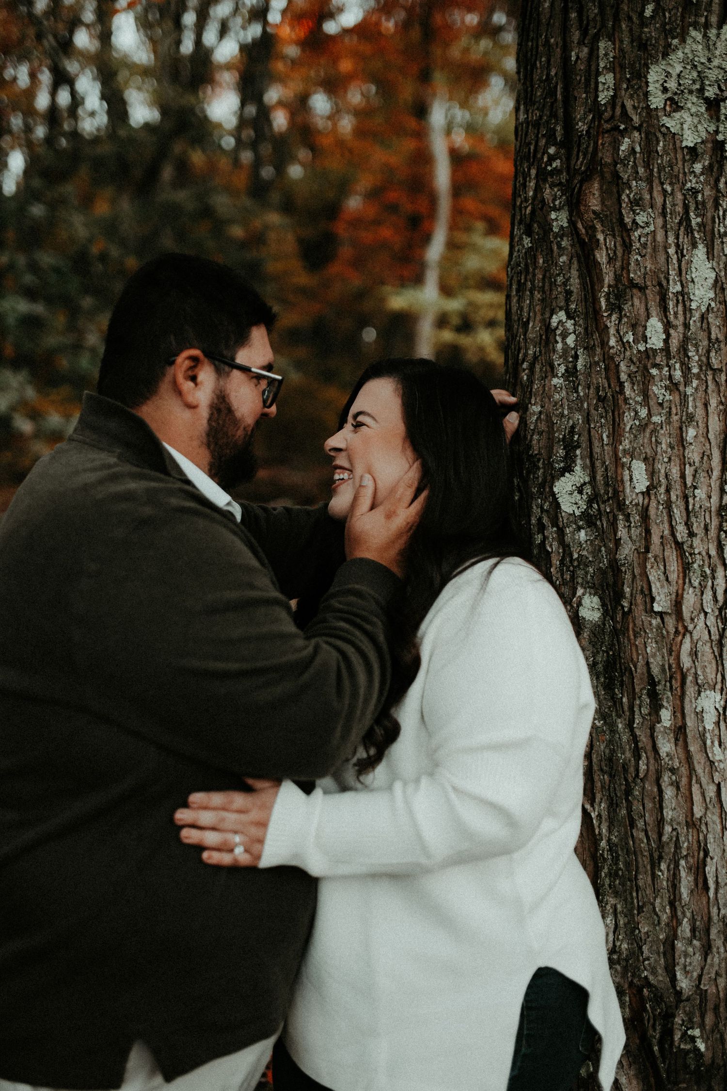 A couple shares moments in a wooded setting with autumn foliage while wearing black and white attire. Pittsburgh Wedding Photographer