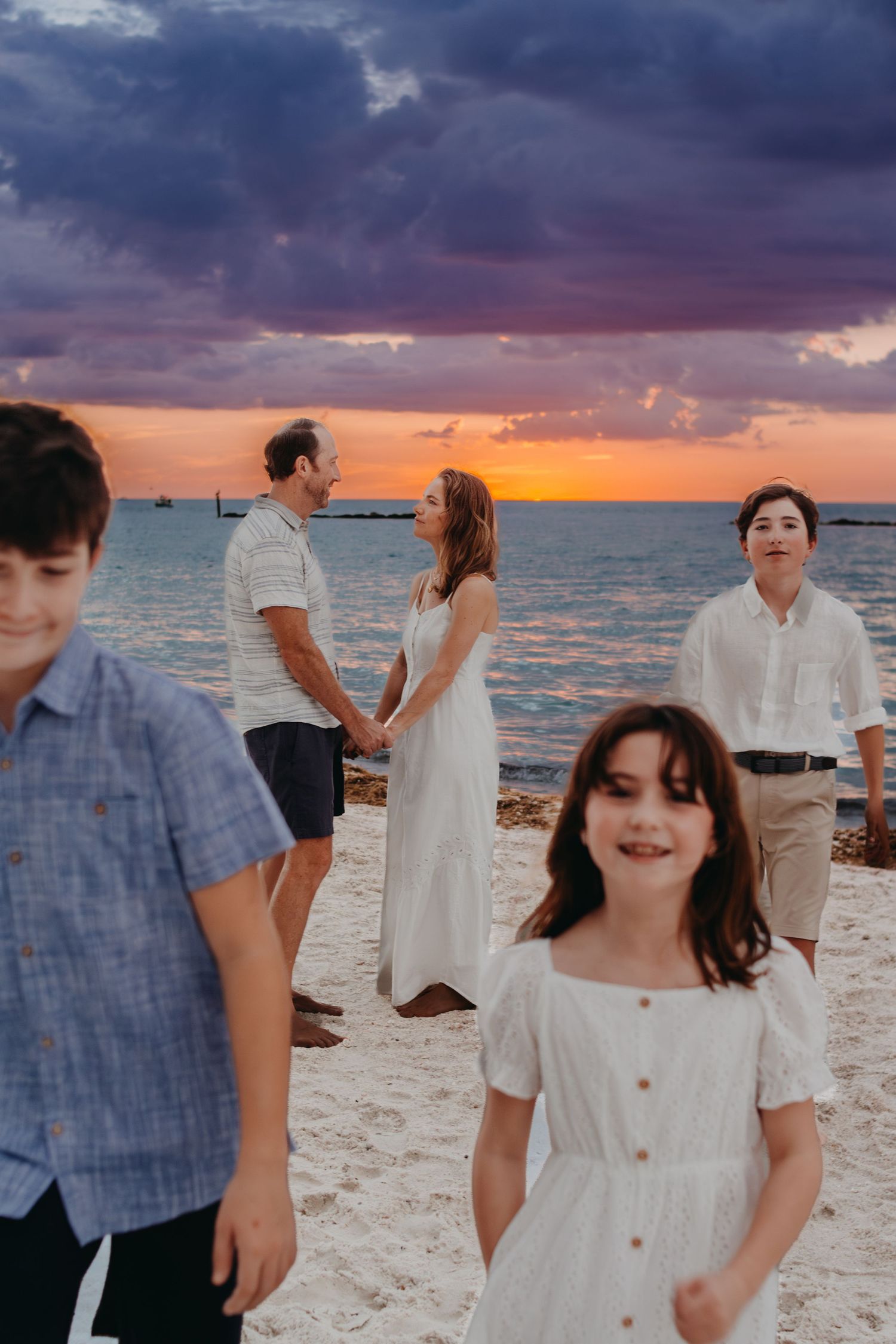 A series of candid beach photos at sunset with people in white and blue outfits enjoying the coastal scenery.